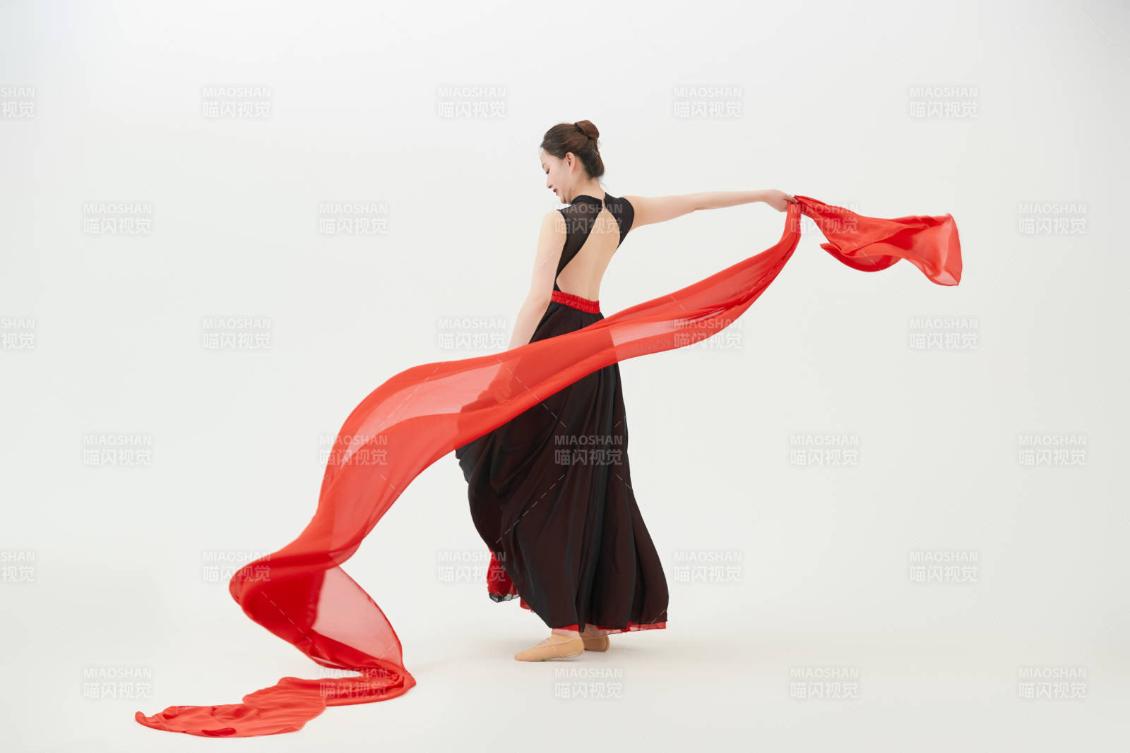 身穿紅黑相間的舞蹈長裙翩翩起舞的少女