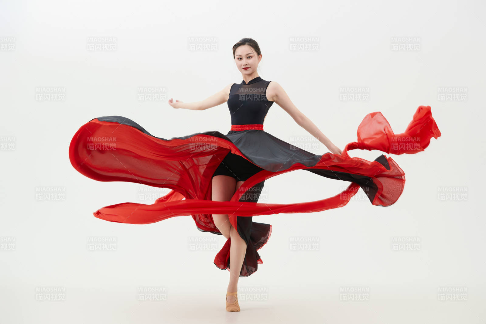 身穿紅黑相間的舞蹈長裙翩翩起舞的少女
