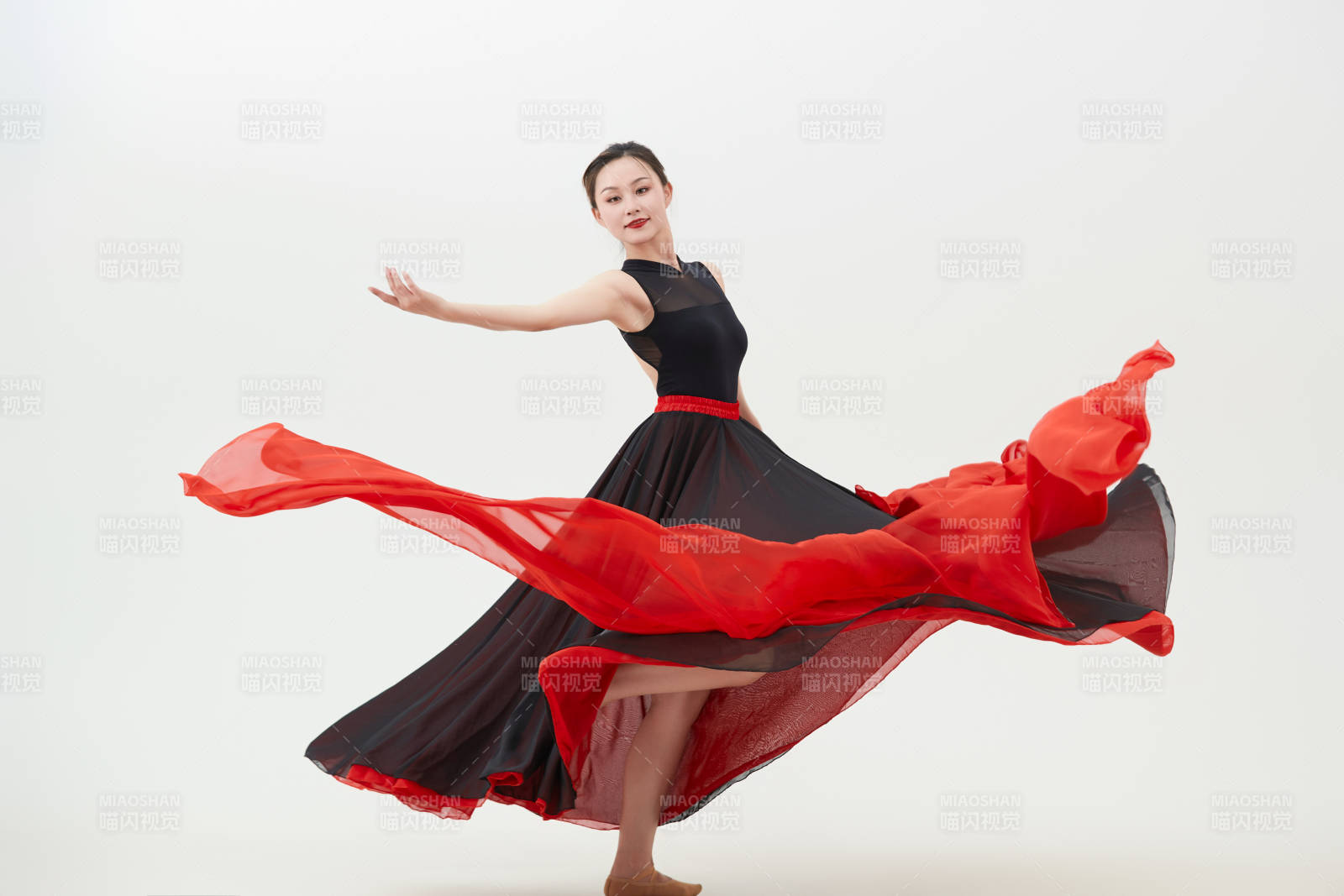 身穿紅黑相間的舞蹈長裙翩翩起舞的少女