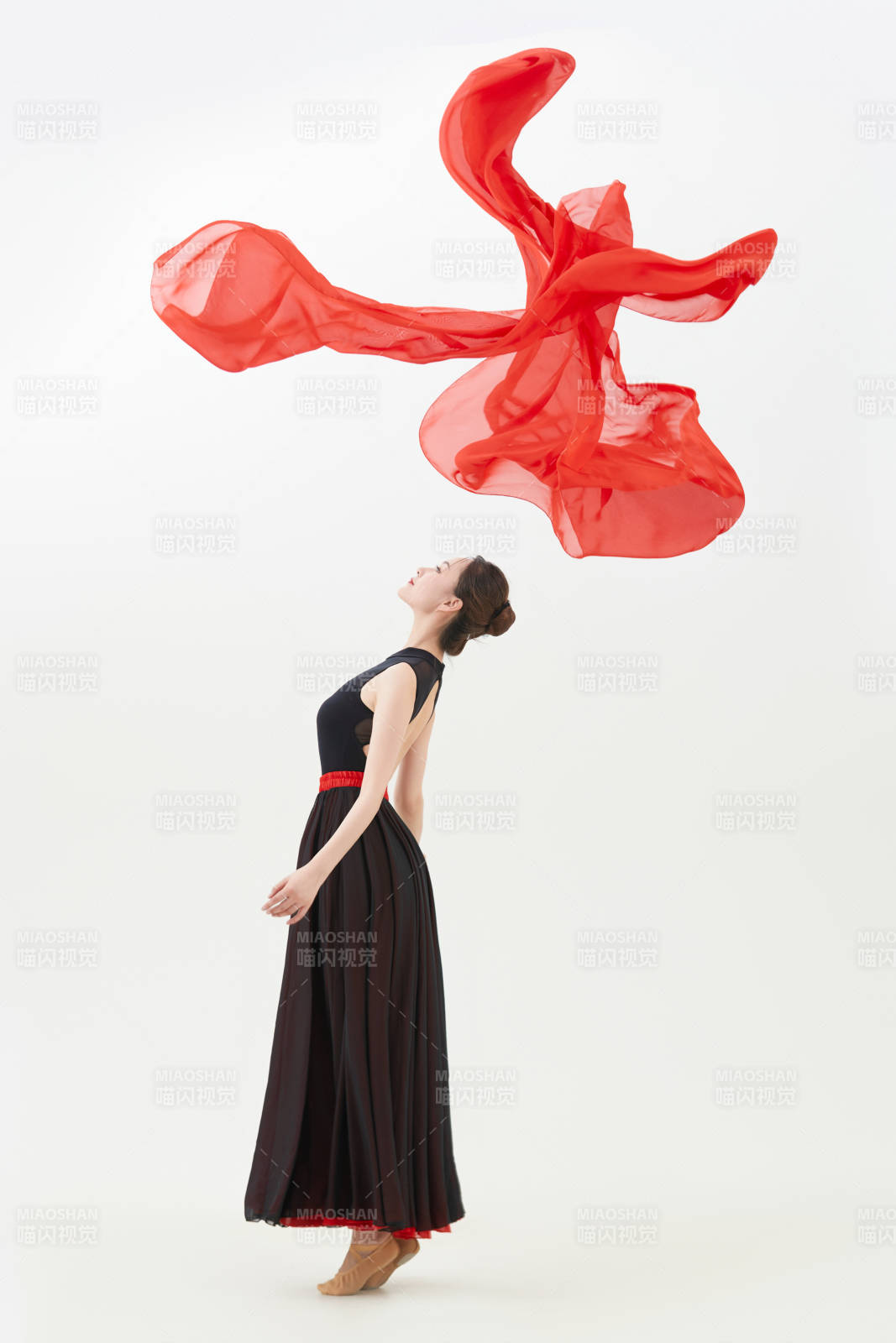 身穿紅黑相間的舞蹈長裙翩翩起舞的少女