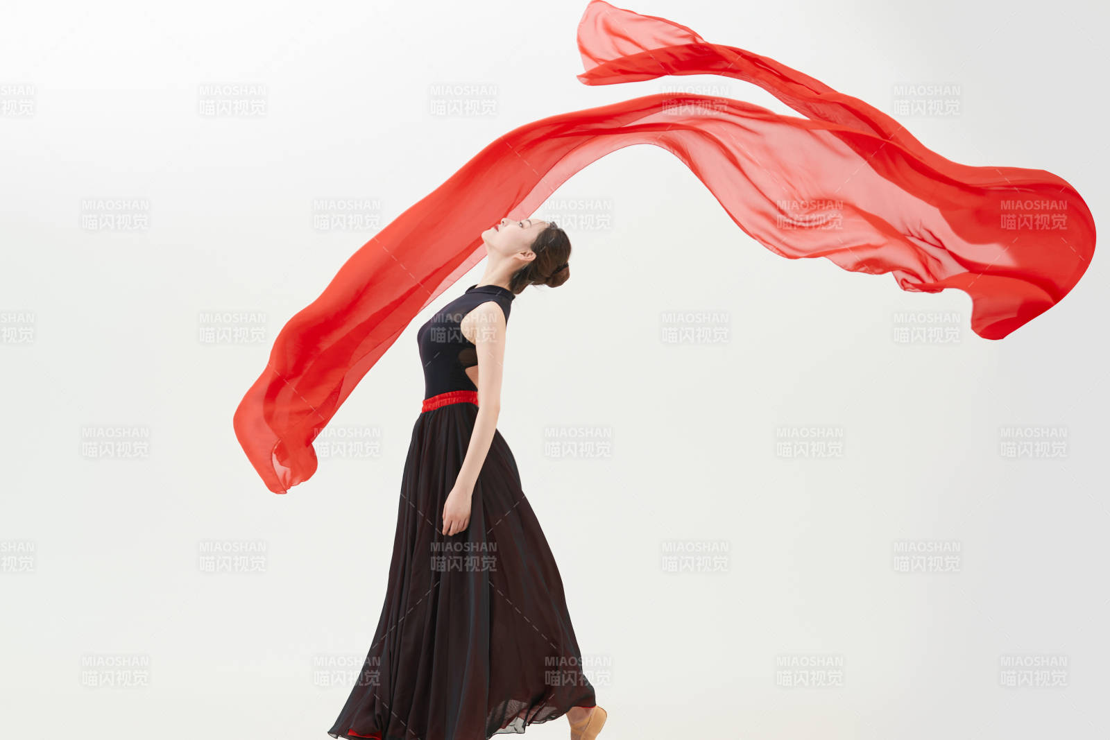 身穿紅黑相間的舞蹈長裙翩翩起舞的少女