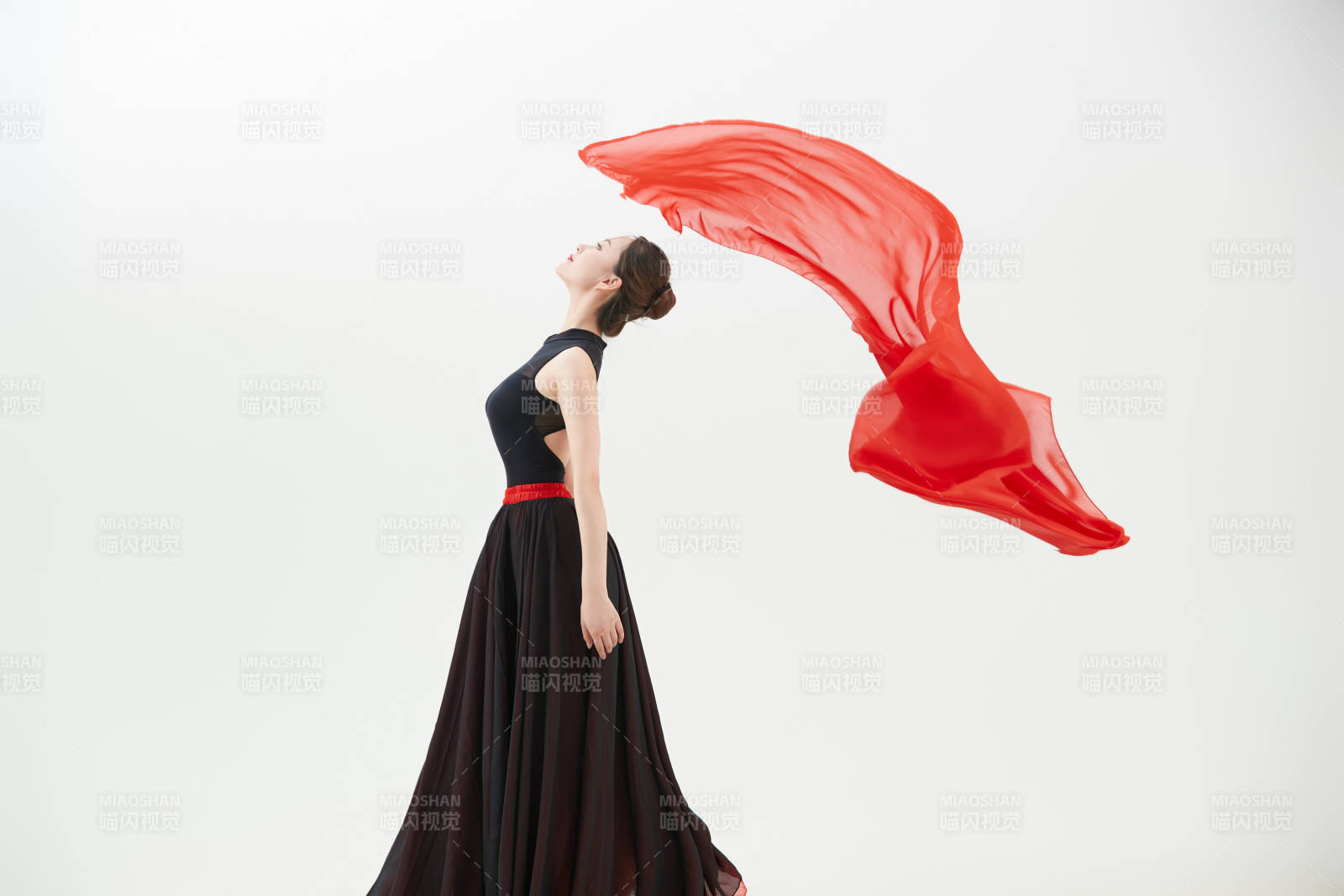 身穿紅黑相間的舞蹈長裙翩翩起舞的少女