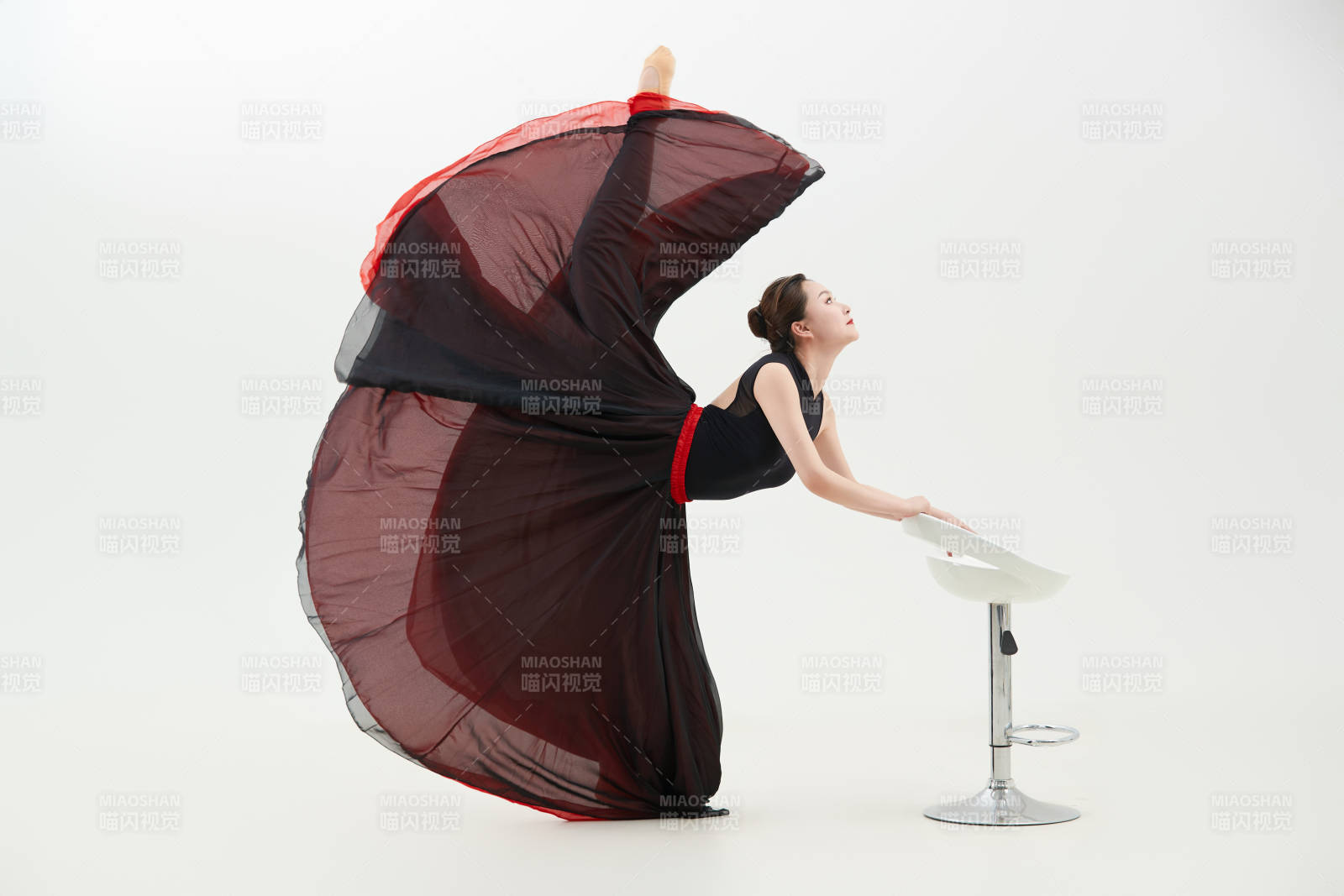 身穿紅黑相間的舞蹈長裙翩翩起舞的少女