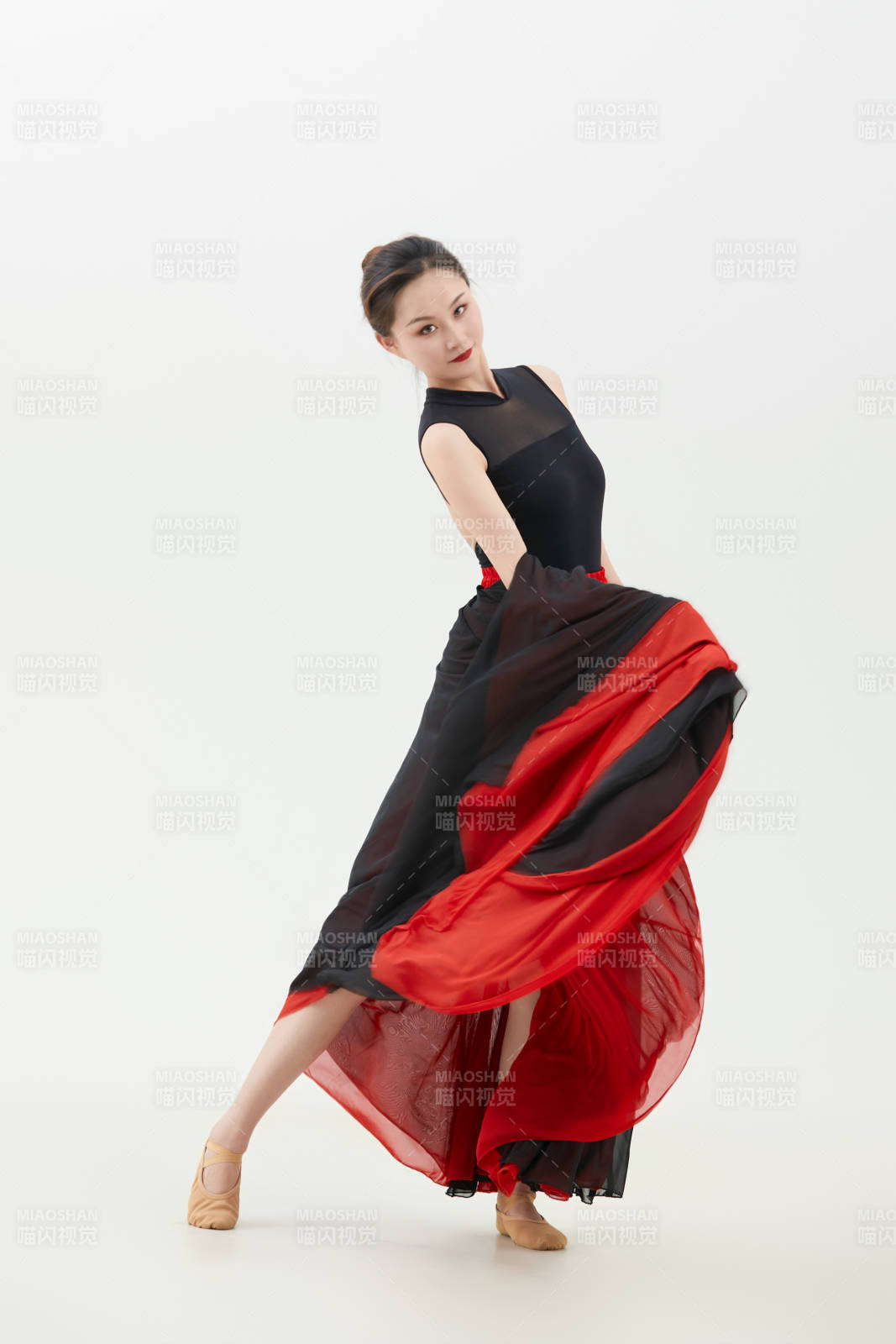 身穿紅黑相間的舞蹈長裙翩翩起舞的少女