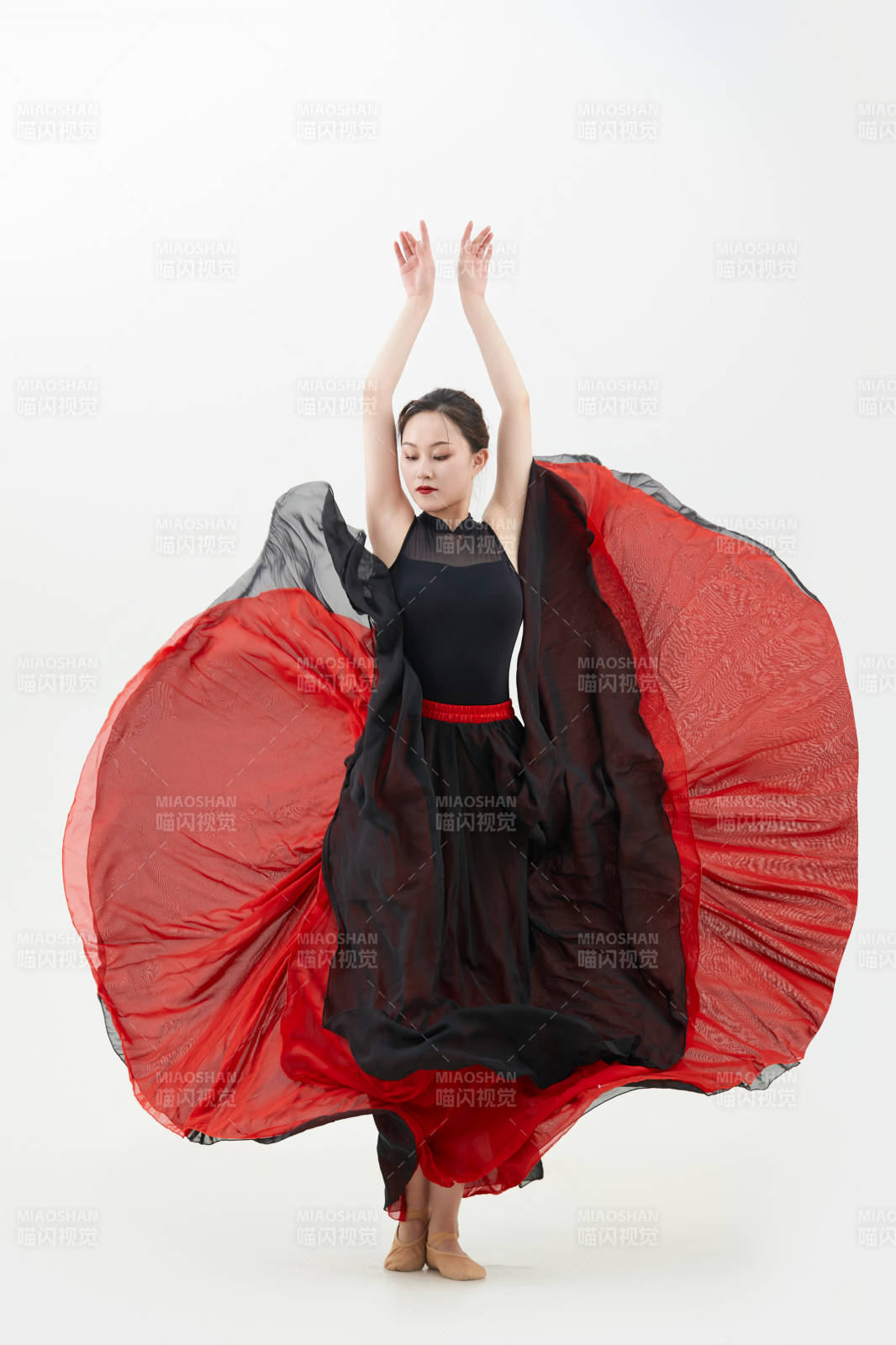 身穿紅黑相間的舞蹈長裙翩翩起舞的少女