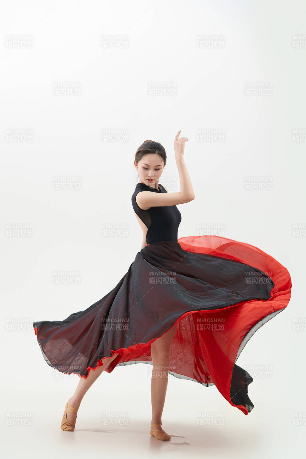 身穿紅黑相間的舞蹈長裙翩翩起舞的少女