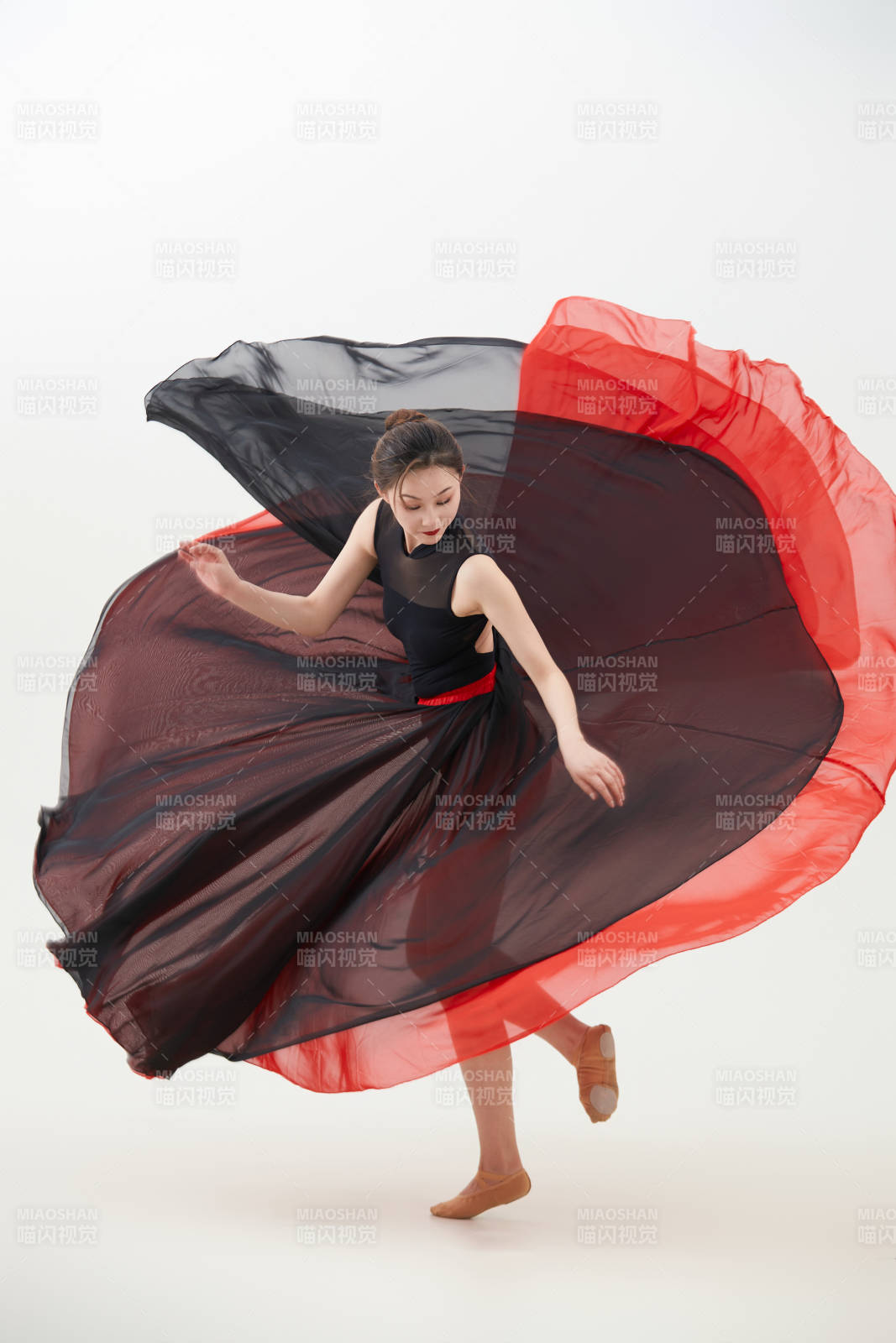 身穿紅黑相間的舞蹈長(zhǎng)裙翩翩起舞的少女