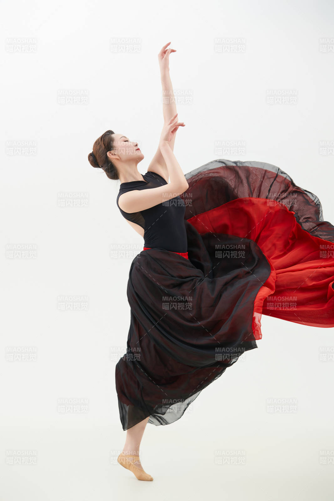 身穿紅黑相間的舞蹈長裙翩翩起舞的少女