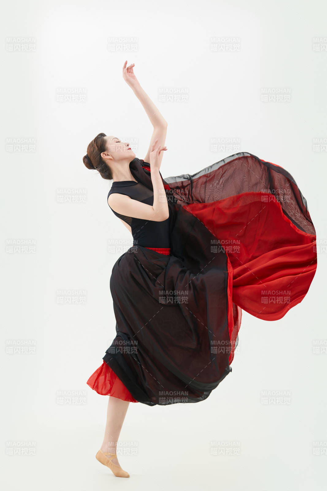 身穿紅黑相間的舞蹈長裙翩翩起舞的少女