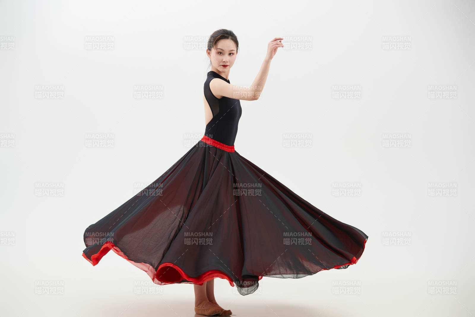 身穿紅黑相間的舞蹈長裙翩翩起舞的少女