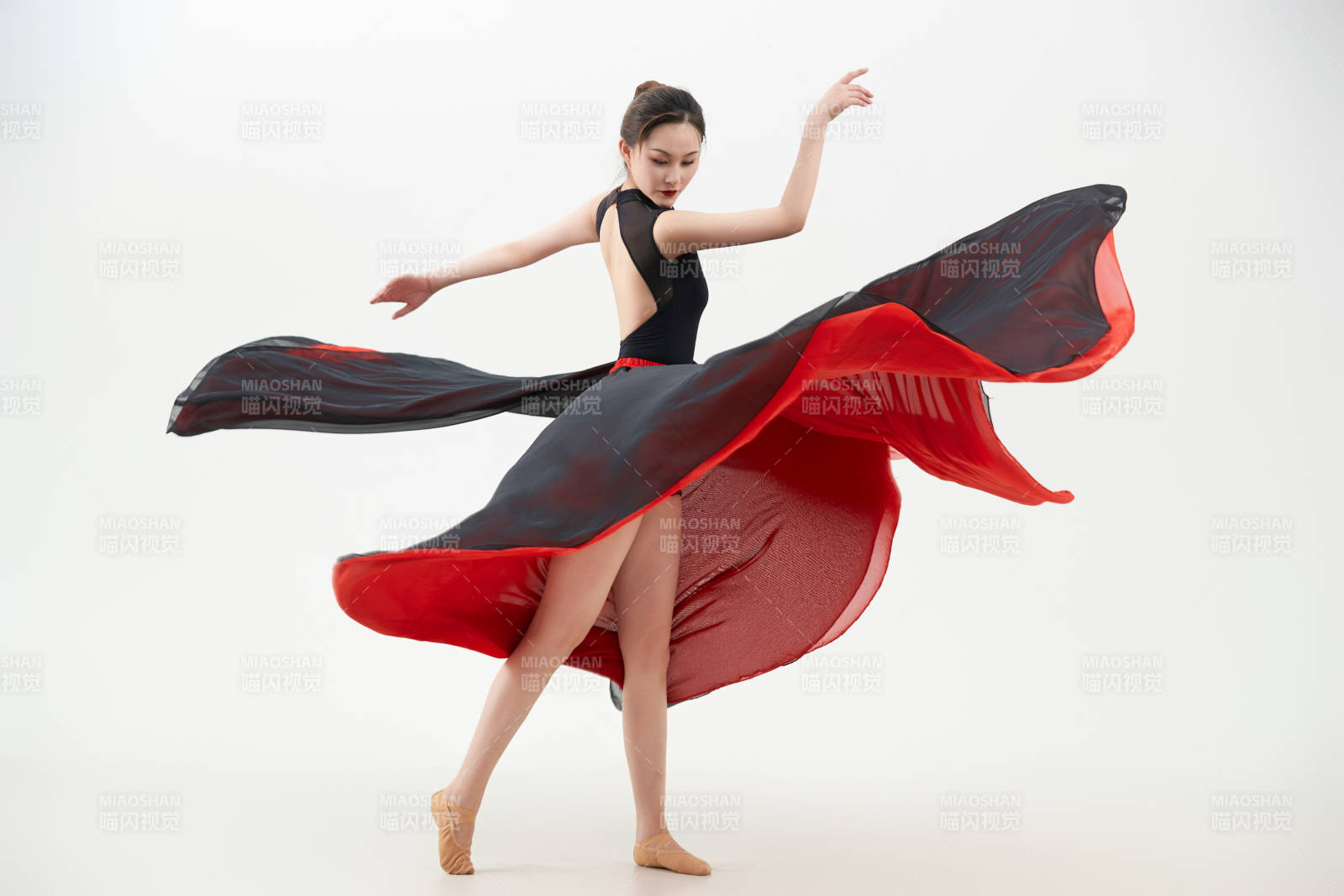 身穿紅黑相間的舞蹈長裙翩翩起舞的少女