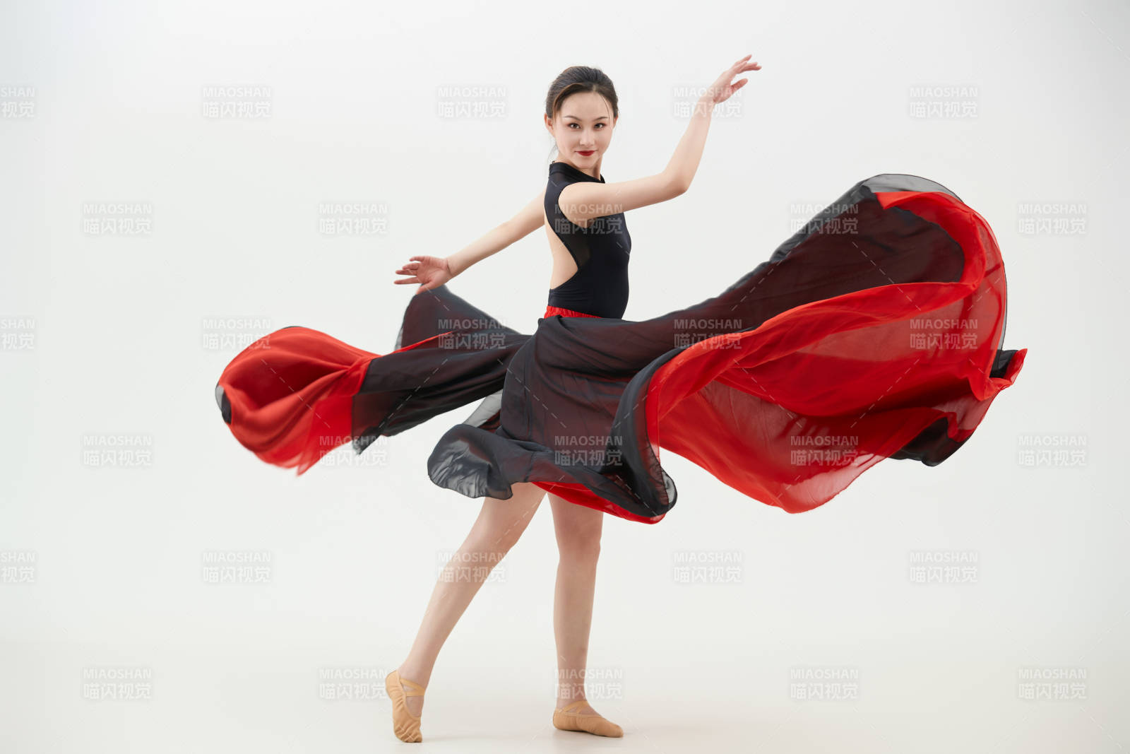 身穿紅黑相間的舞蹈長裙翩翩起舞的少女
