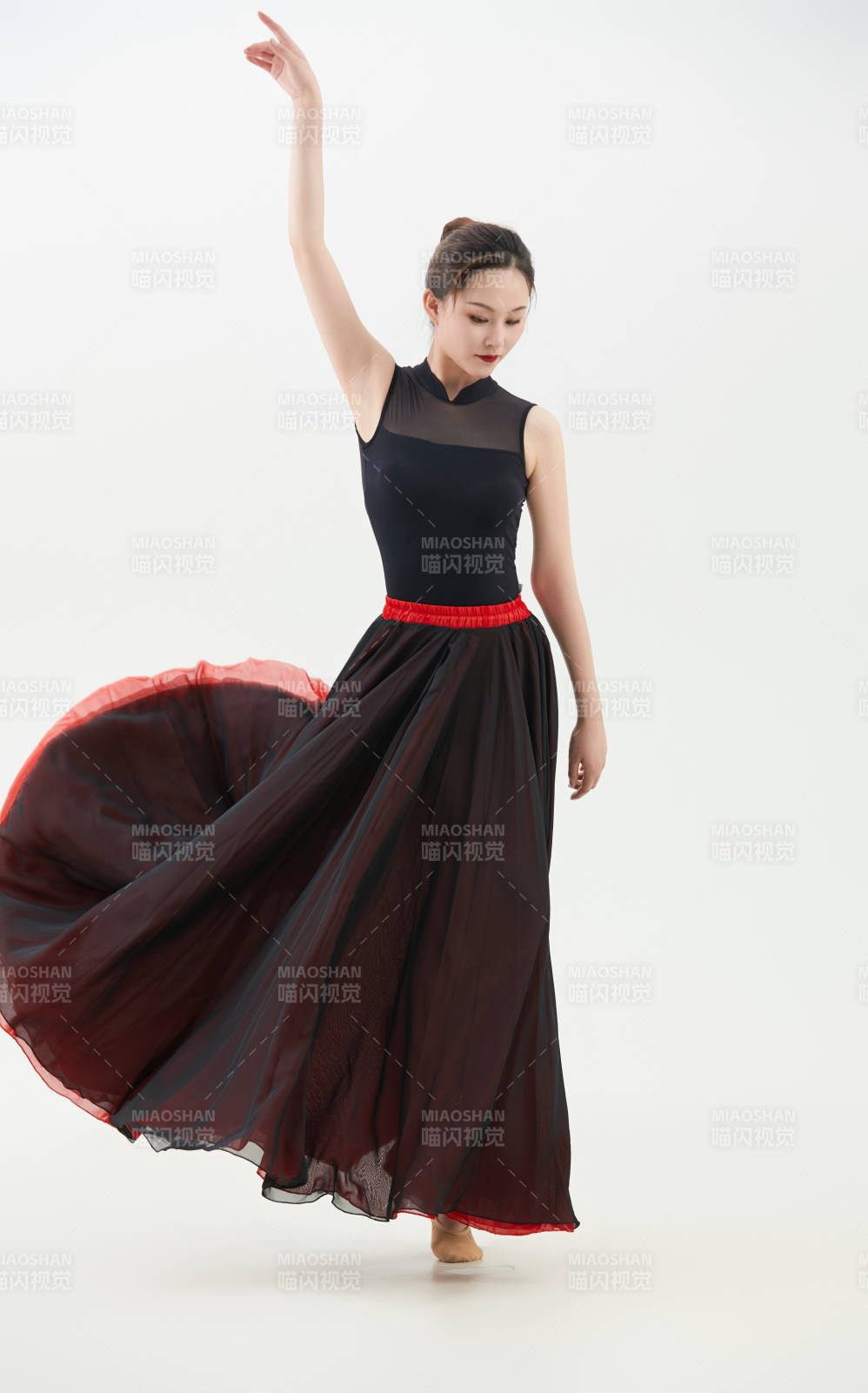 身穿紅黑相間的舞蹈長裙翩翩起舞的少女