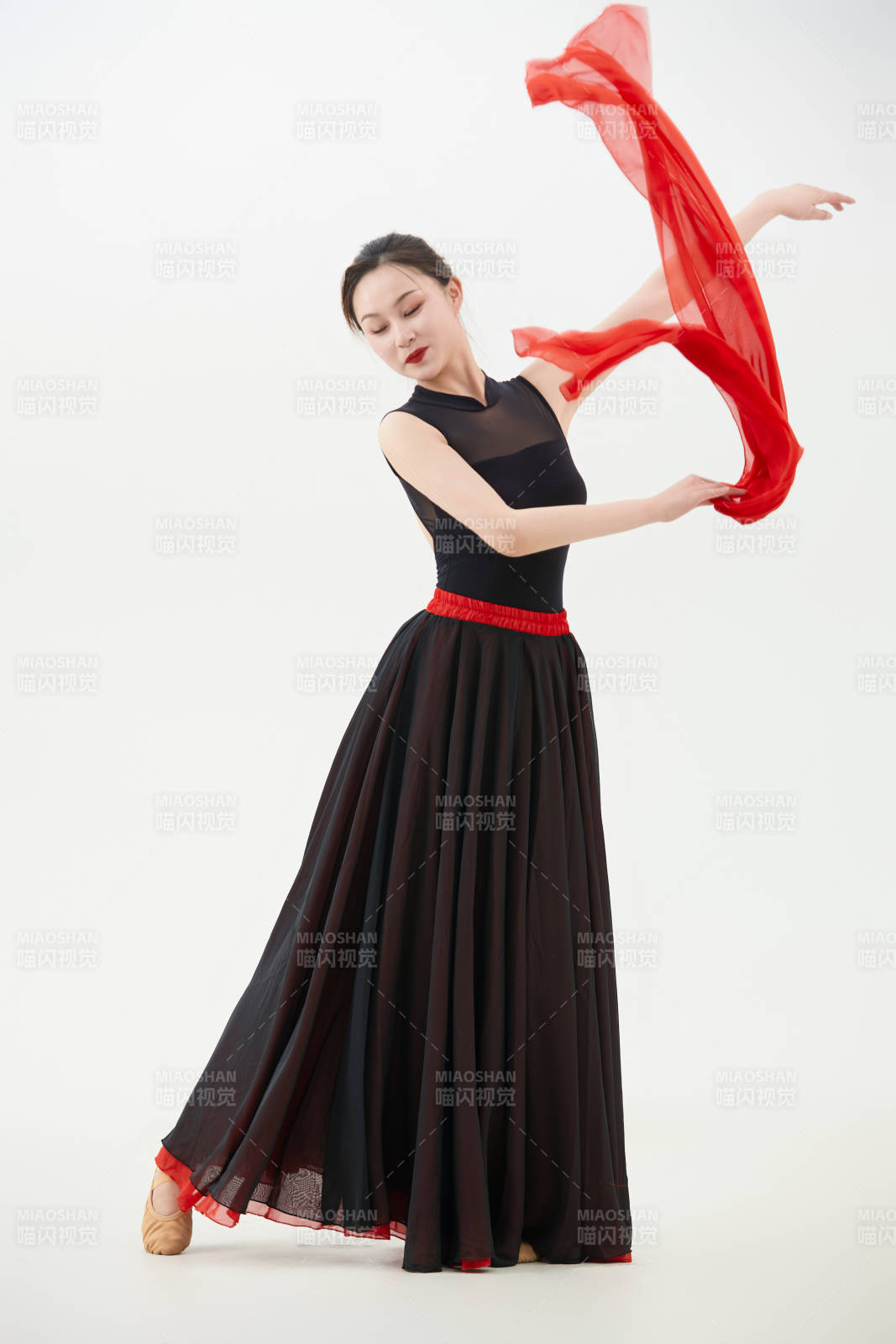 身穿红黑相间的舞蹈长裙翩翩起舞的少女