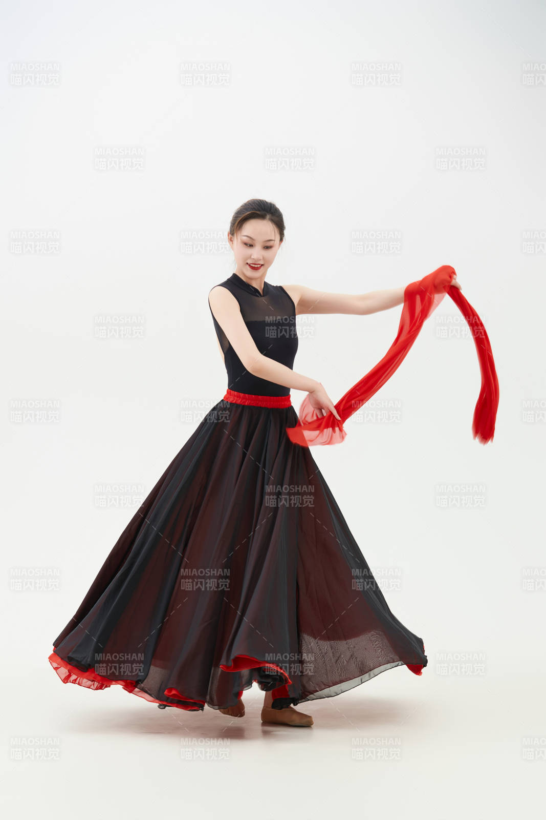 身穿紅黑相間的舞蹈長裙翩翩起舞的少女