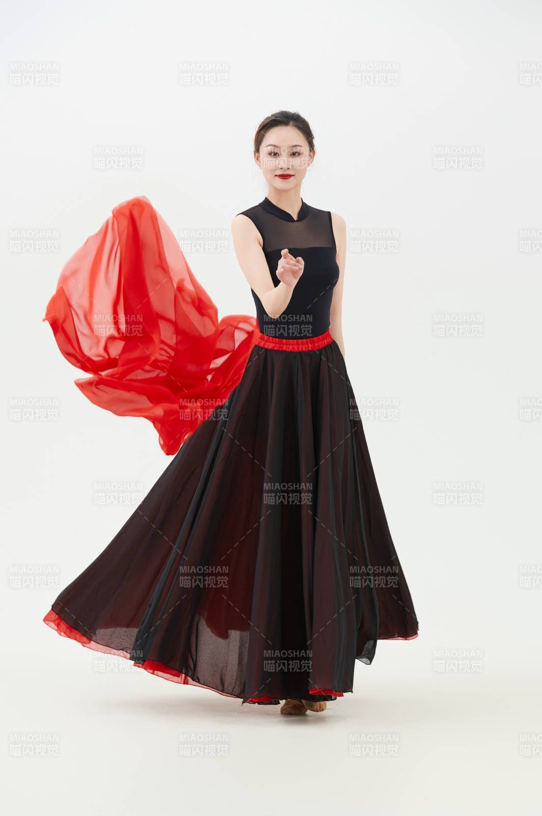 身穿紅黑相間的舞蹈長裙翩翩起舞的少女