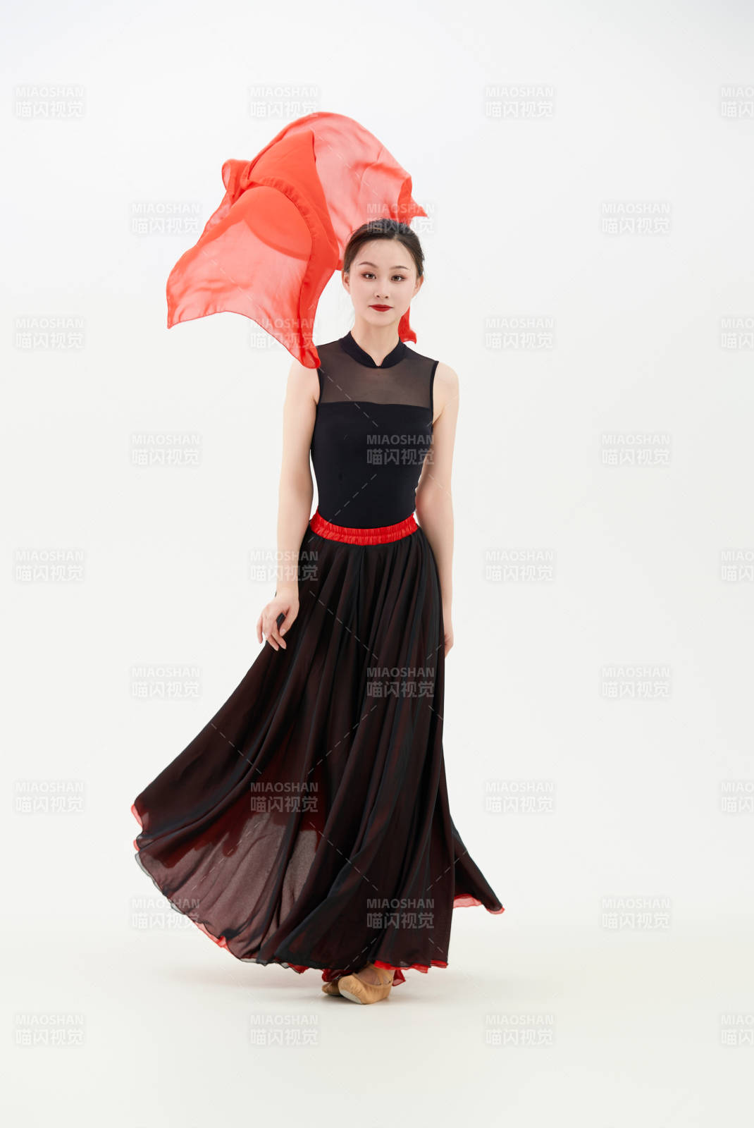 身穿紅黑相間的舞蹈長裙翩翩起舞的少女