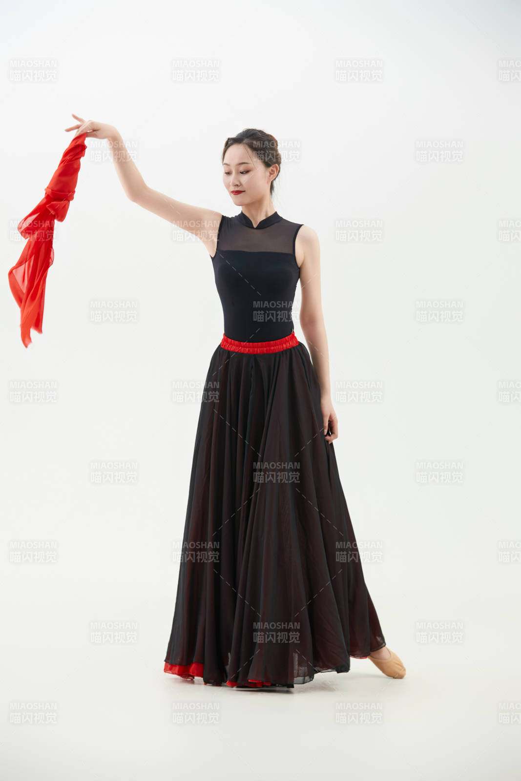 身穿紅黑相間的舞蹈長裙翩翩起舞的少女