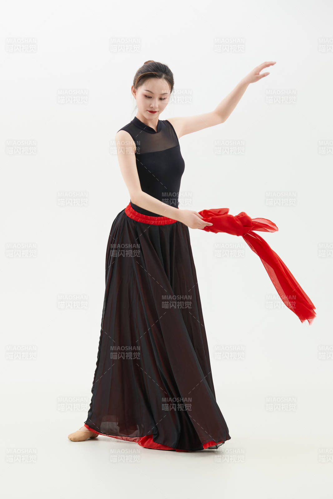 身穿紅黑相間的舞蹈長裙翩翩起舞的少女