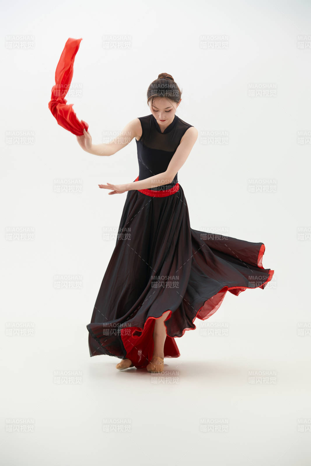 身穿紅黑相間的舞蹈長裙翩翩起舞的少女