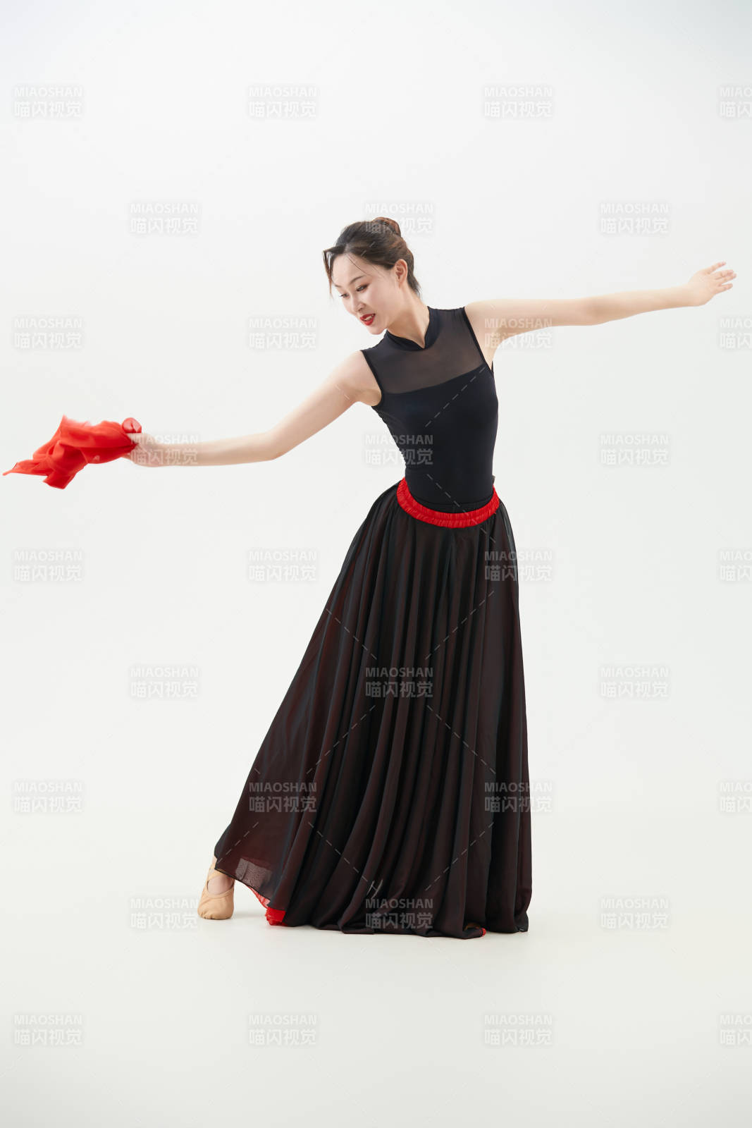 身穿紅黑相間的舞蹈長裙翩翩起舞的少女