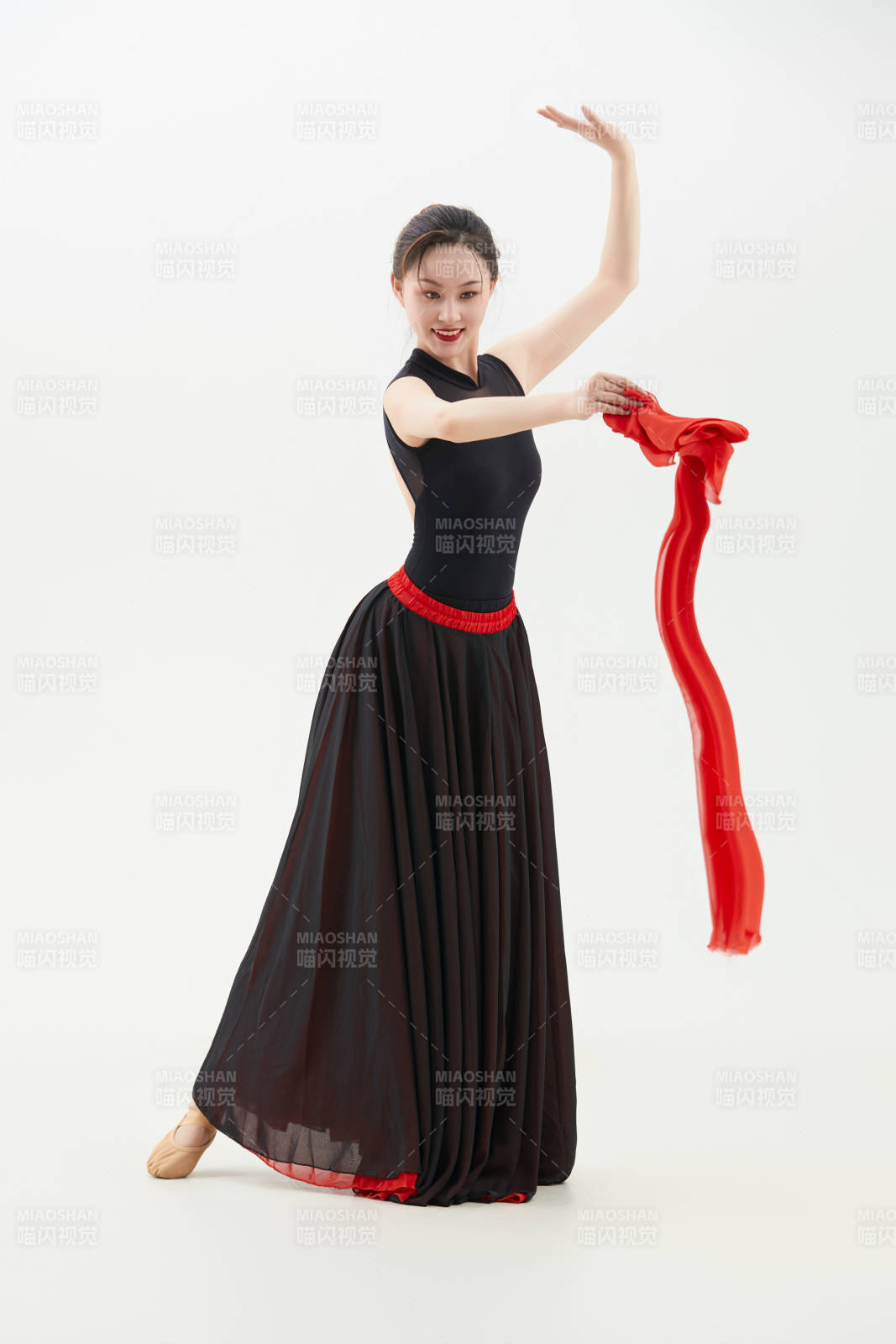 身穿紅黑相間的舞蹈長裙翩翩起舞的少女
