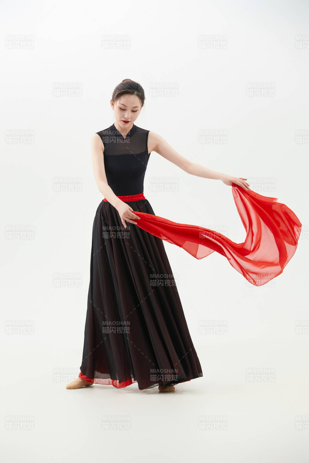 身穿紅黑相間的舞蹈長裙翩翩起舞的少女