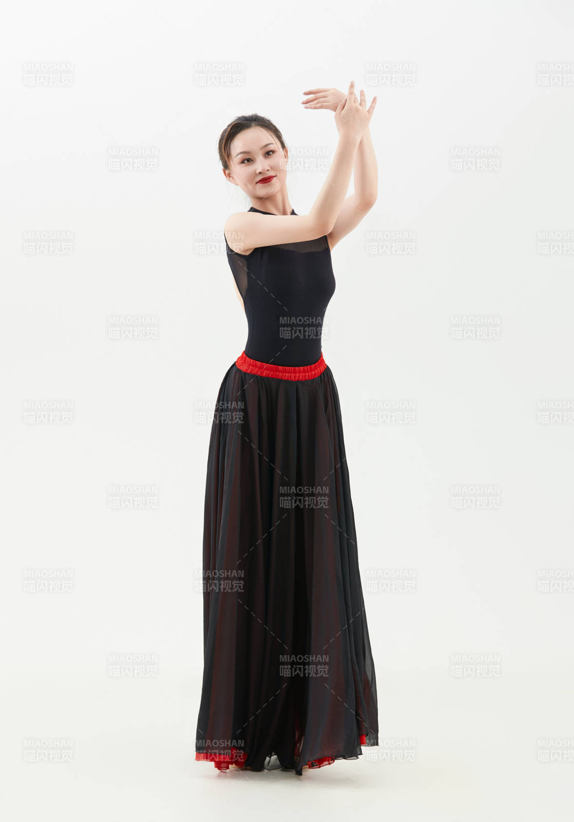 身穿紅黑相間的舞蹈長裙翩翩起舞的少女