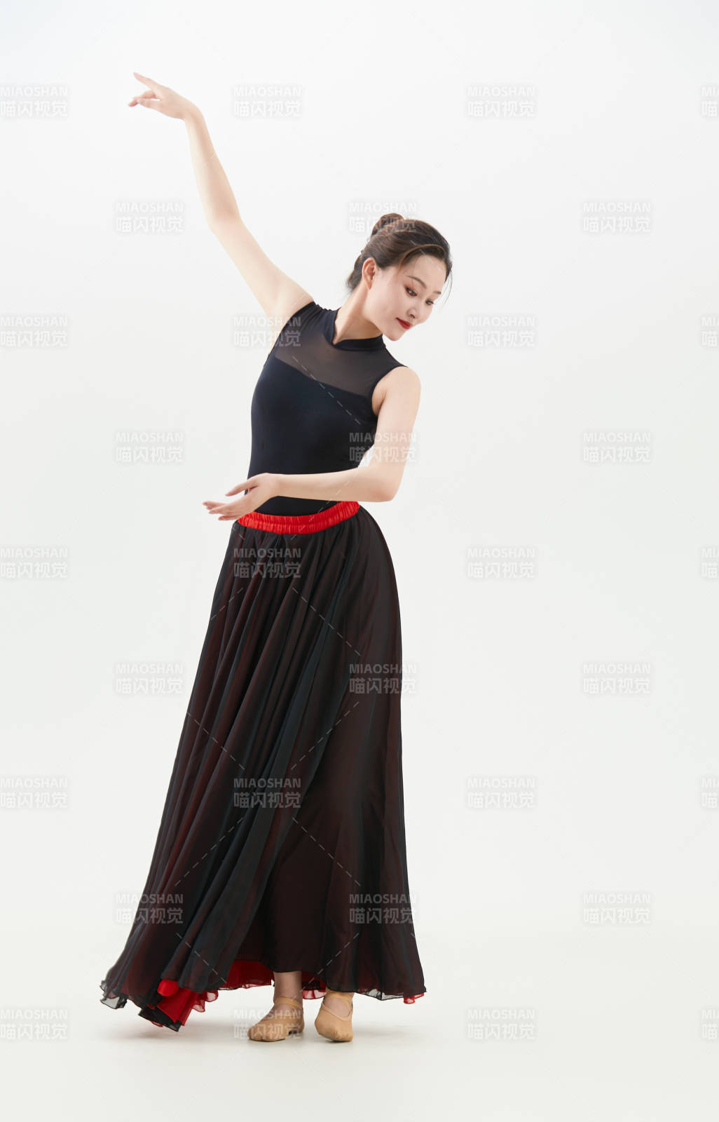 身穿紅黑相間的舞蹈長裙翩翩起舞的少女
