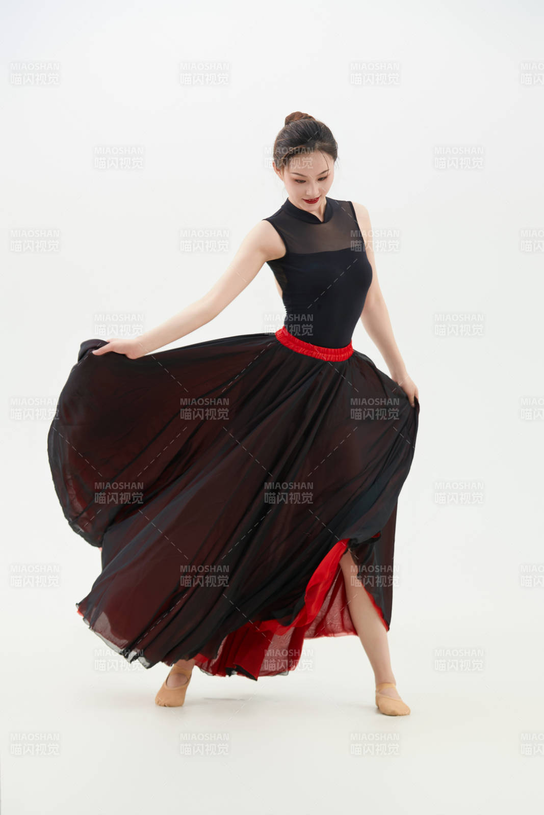 身穿紅黑相間的舞蹈長裙翩翩起舞的少女