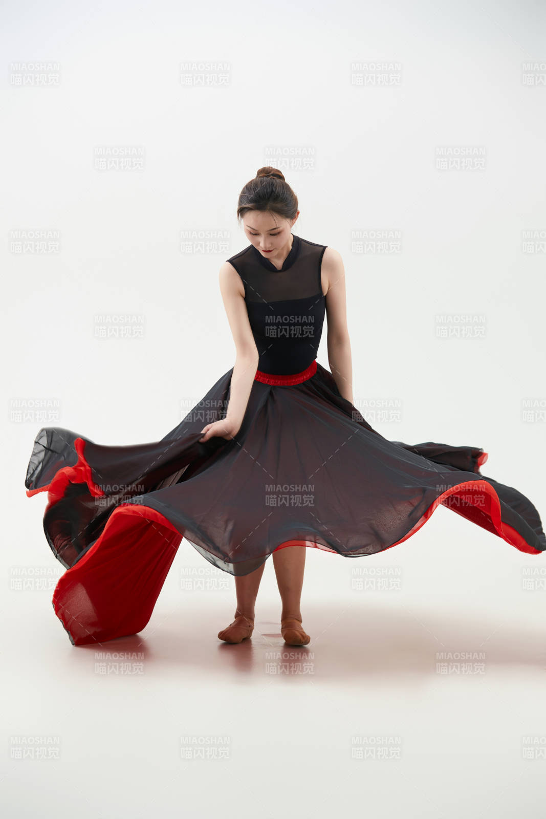 身穿紅黑相間的舞蹈長裙翩翩起舞的少女
