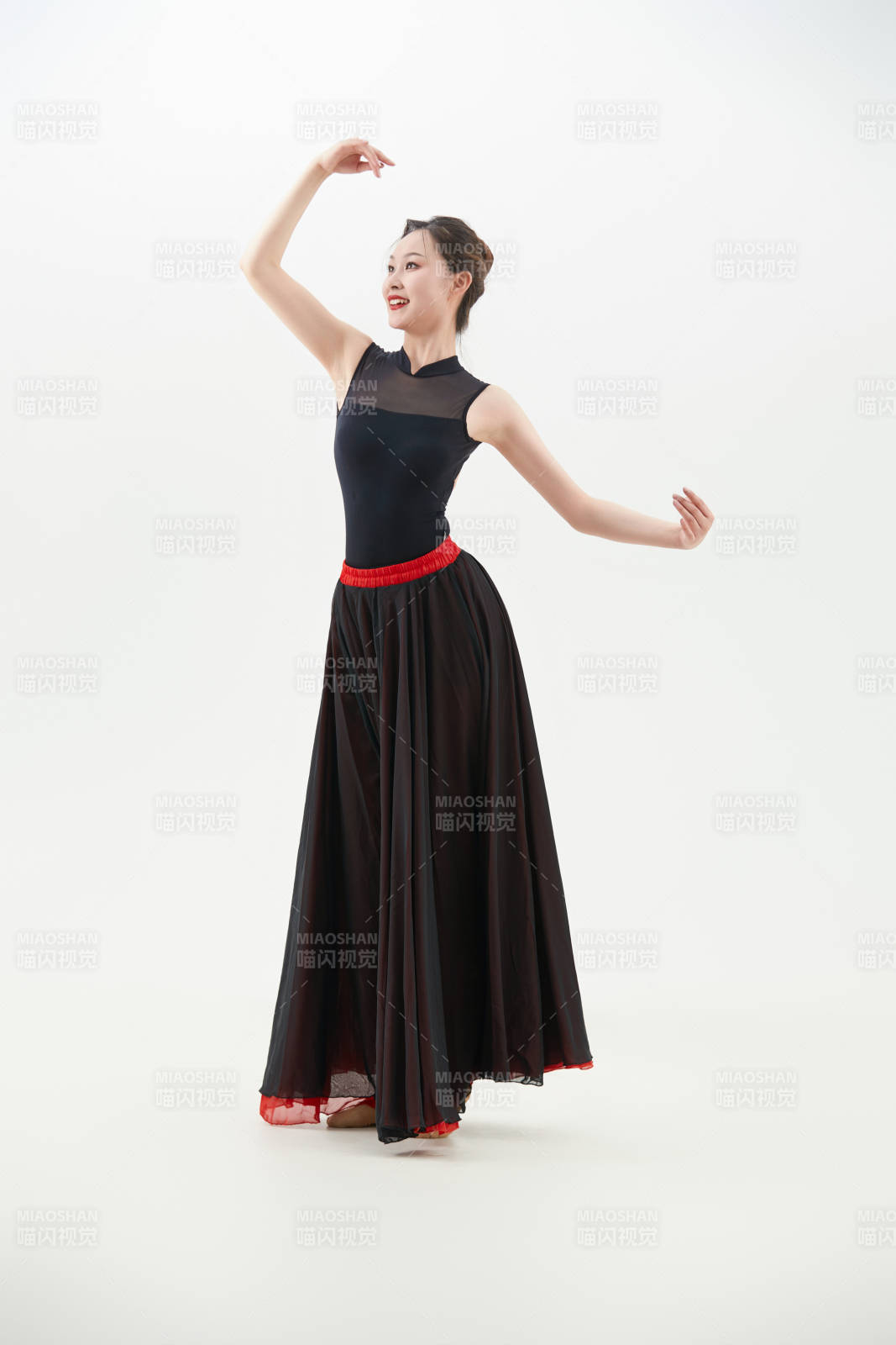 身穿紅黑相間的舞蹈長裙翩翩起舞的少女