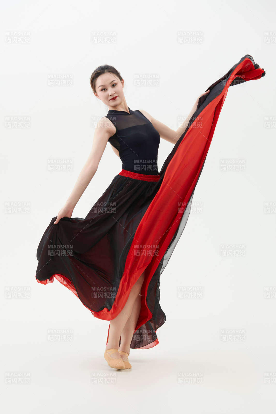 身穿紅黑相間的舞蹈長裙翩翩起舞的少女