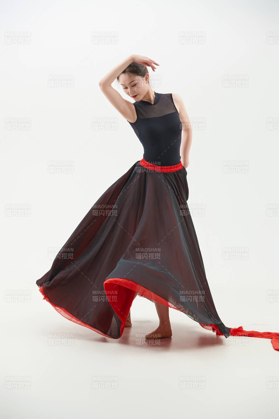 身穿紅黑相間的舞蹈長裙翩翩起舞的少女
