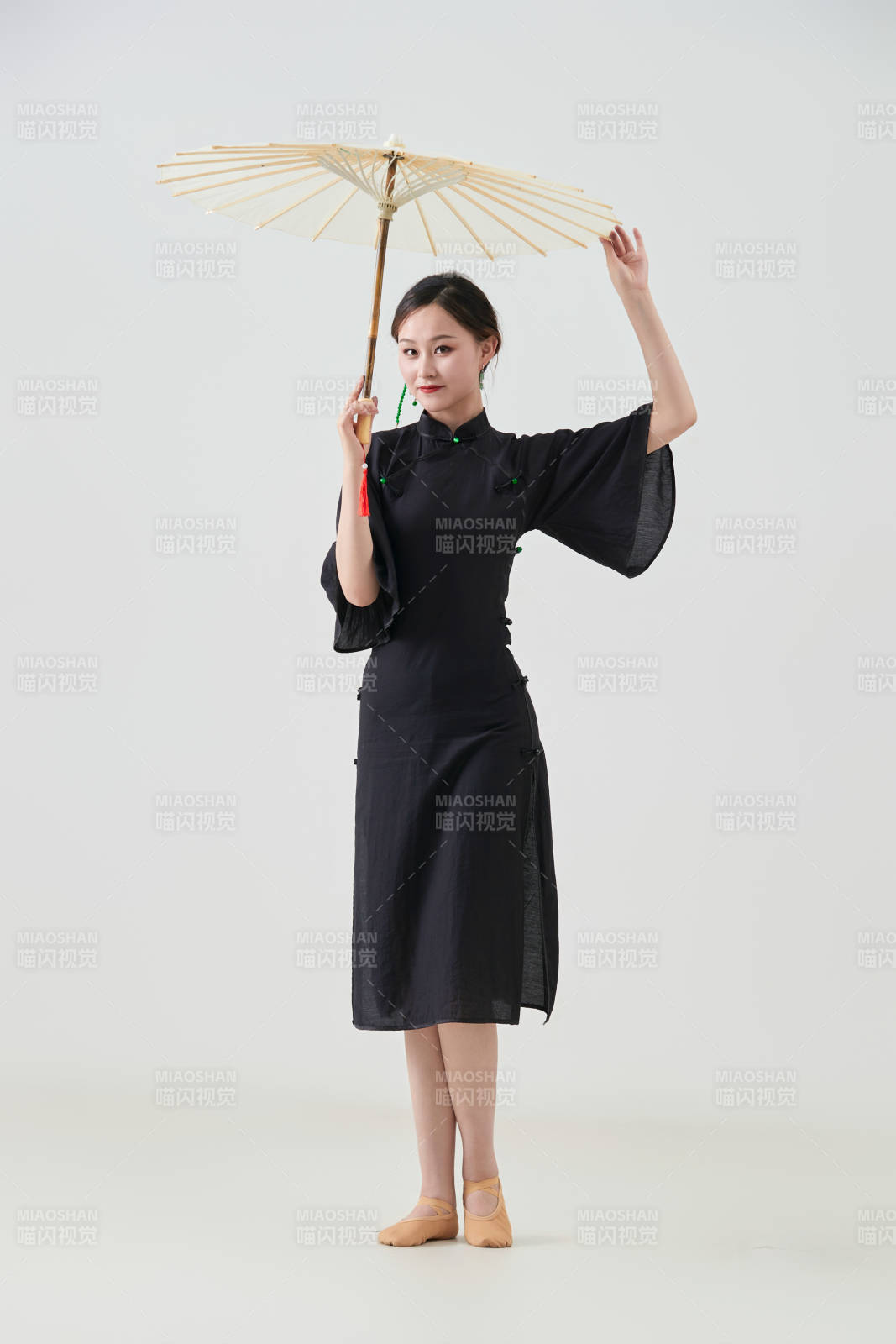 穿中式旗袍手拿油紙傘翩翩舞蹈的亞洲少女舞者