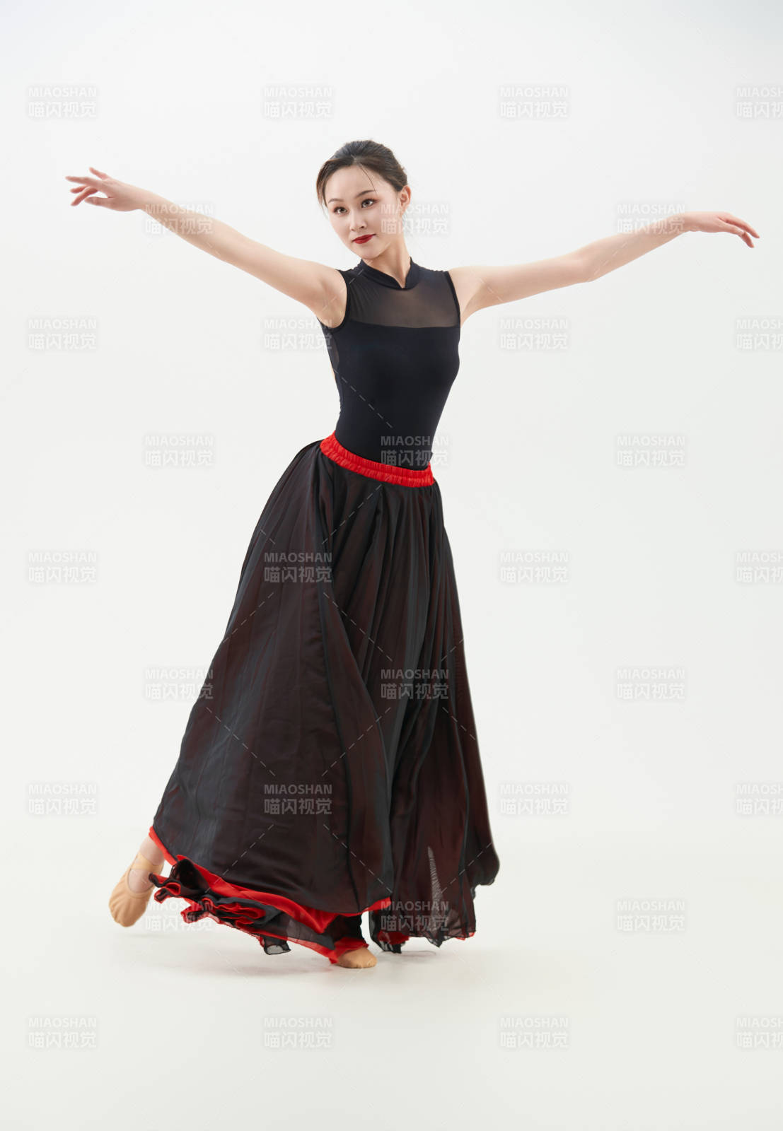身穿紅黑相間的舞蹈長(zhǎng)裙翩翩起舞的少女