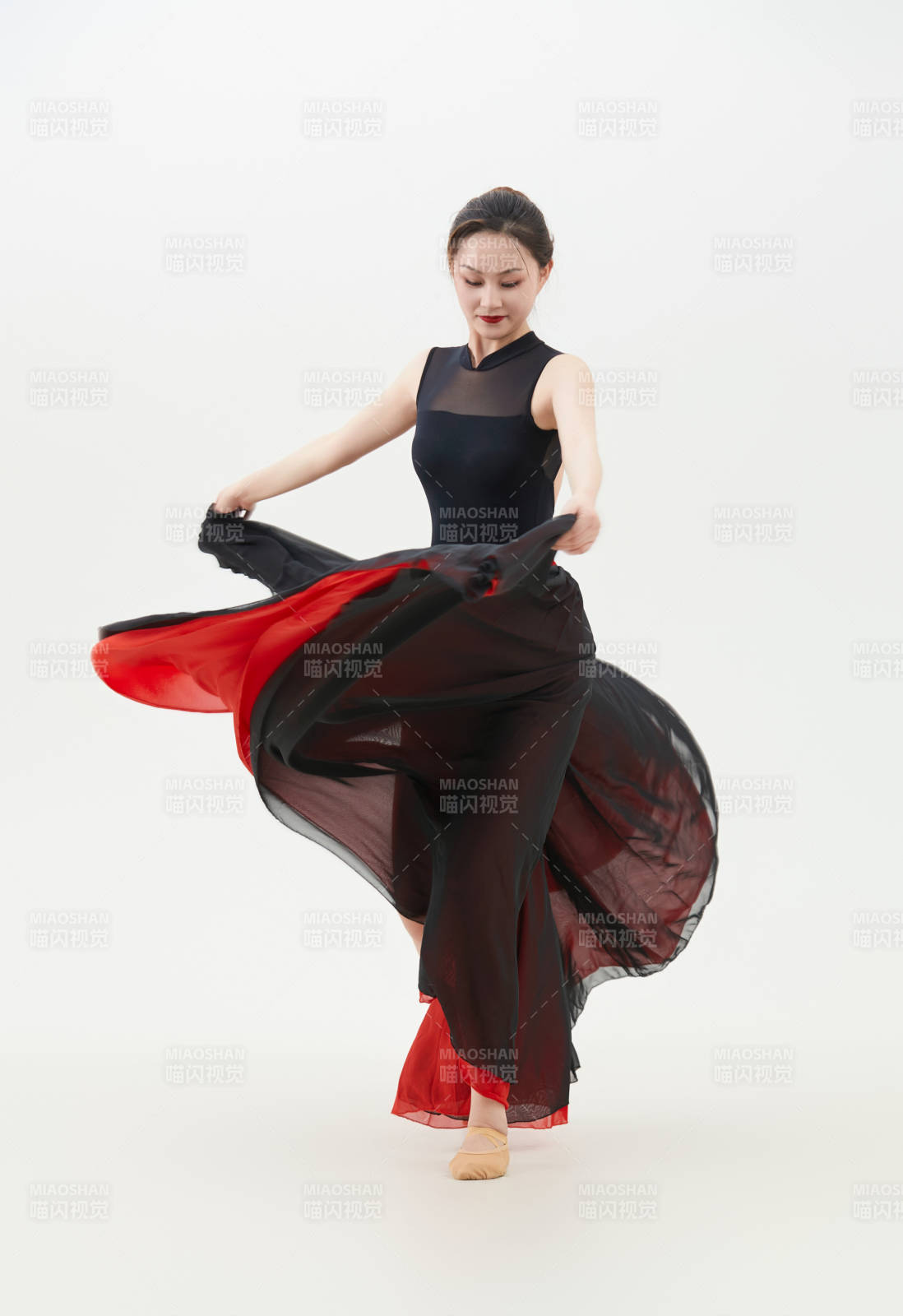 身穿紅黑相間的舞蹈長裙翩翩起舞的少女