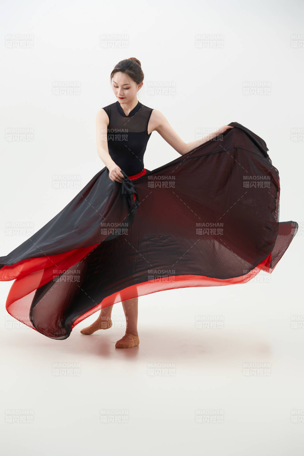 身穿紅黑相間的舞蹈長裙翩翩起舞的少女