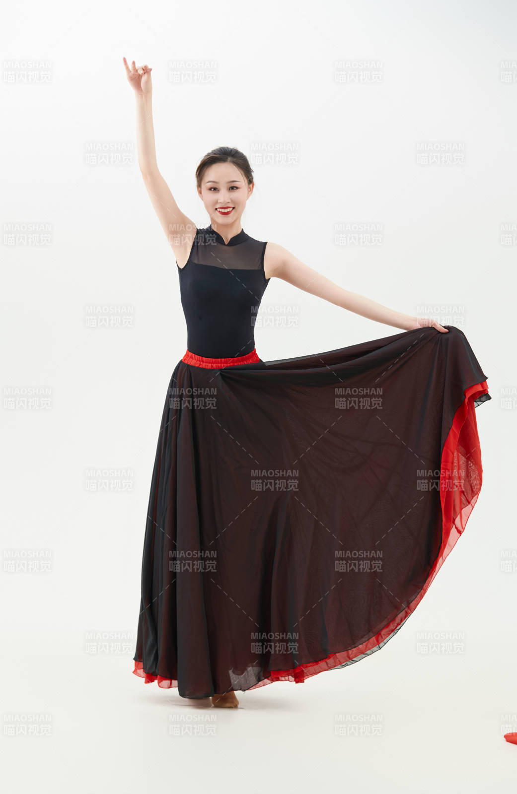 身穿紅黑相間的舞蹈長裙翩翩起舞的少女