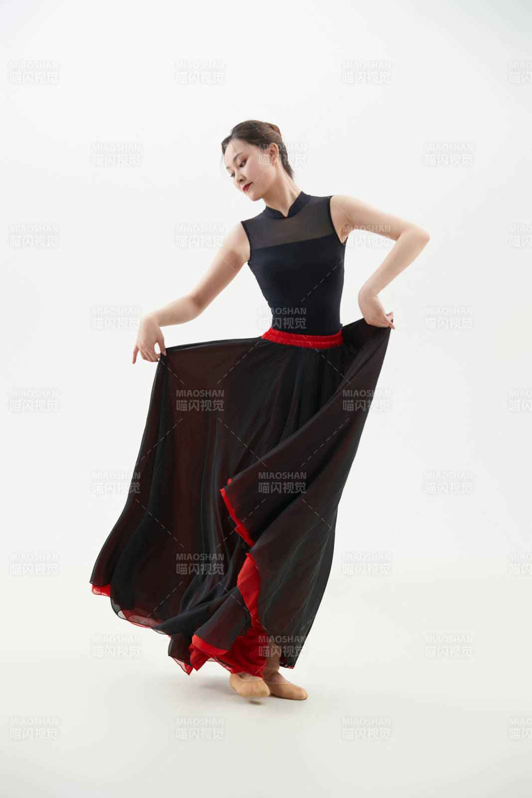 身穿紅黑相間的舞蹈長裙翩翩起舞的少女