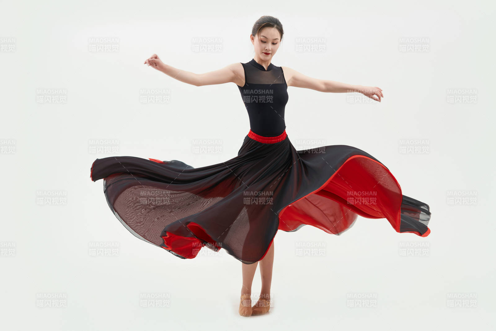 身穿紅黑相間的舞蹈長裙翩翩起舞的少女