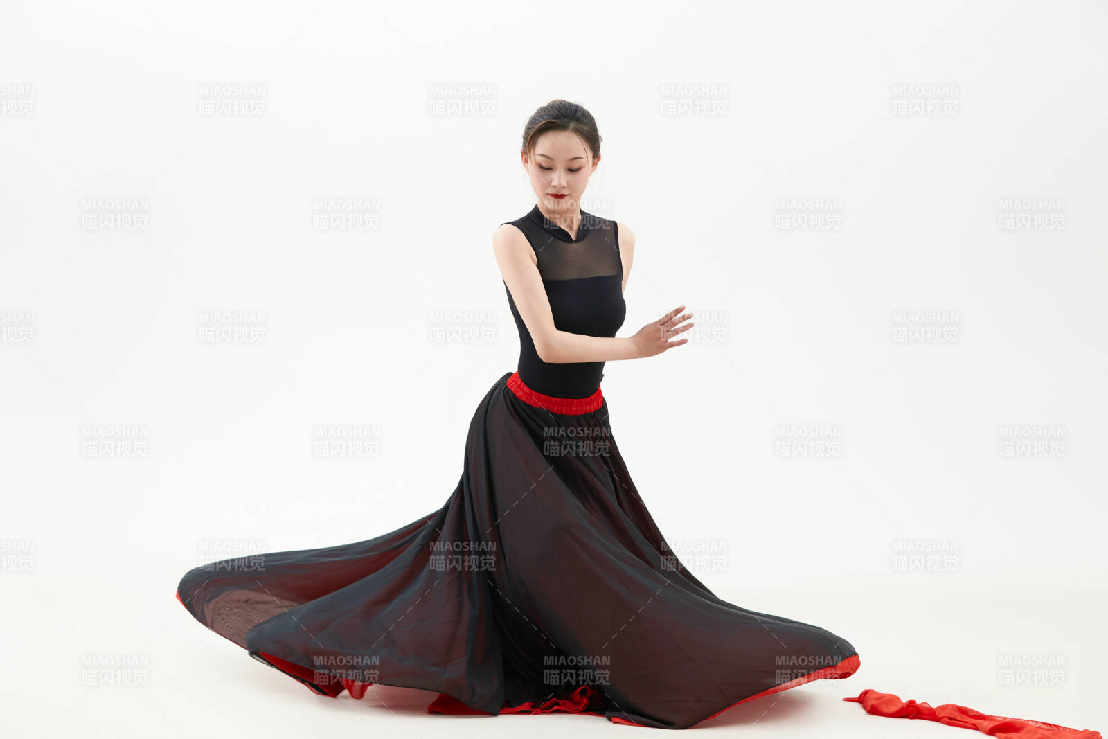 身穿紅黑相間的舞蹈長裙翩翩起舞的少女