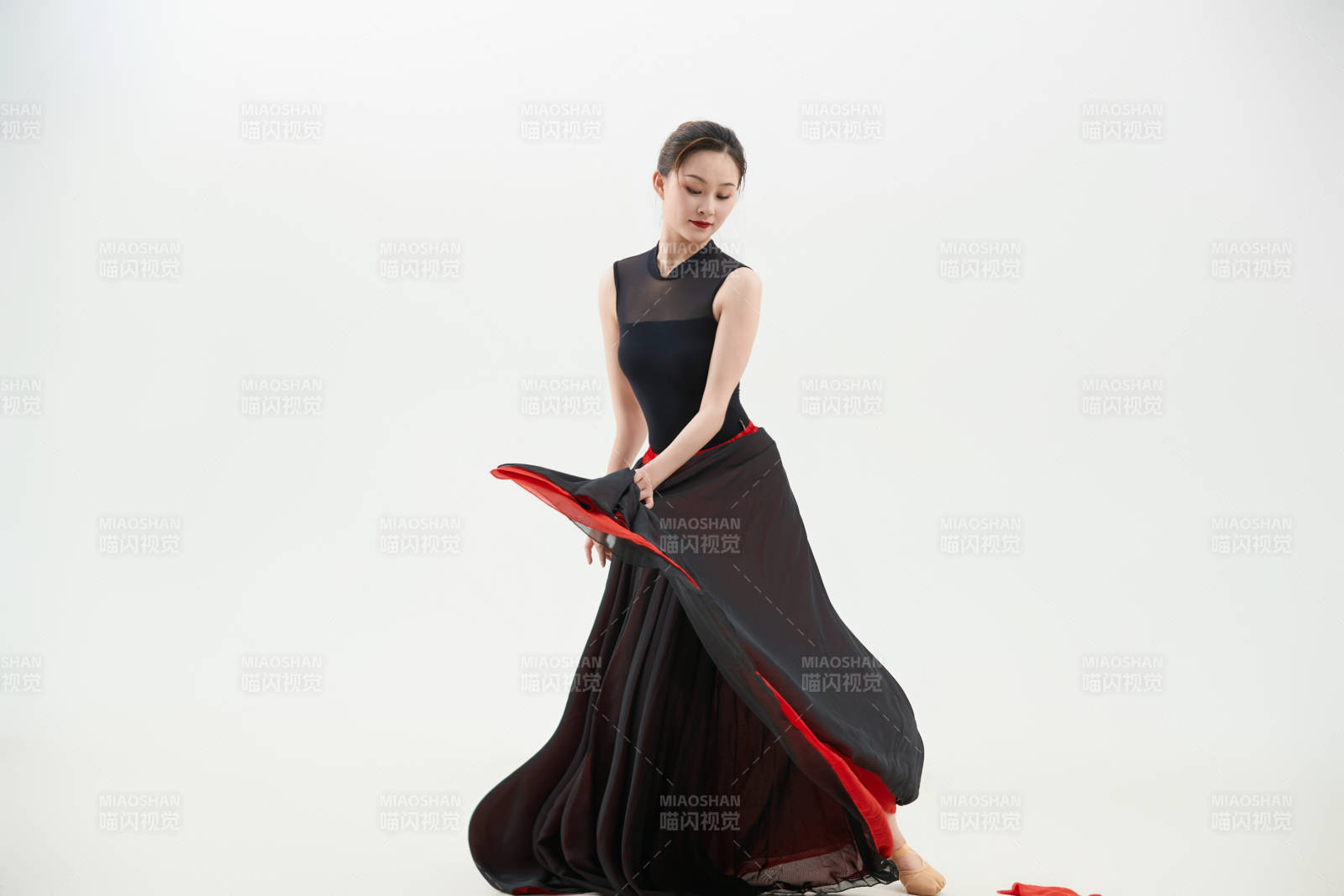 身穿紅黑相間的舞蹈長裙翩翩起舞的少女