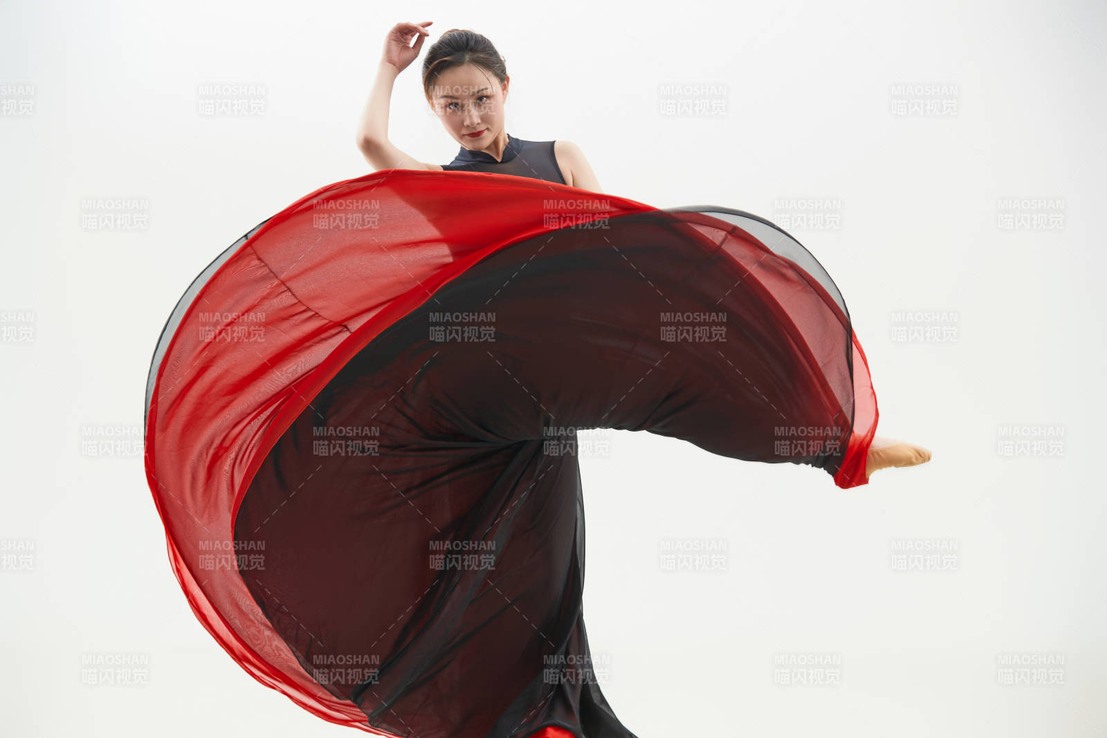 身穿紅黑相間的舞蹈長裙翩翩起舞的少女