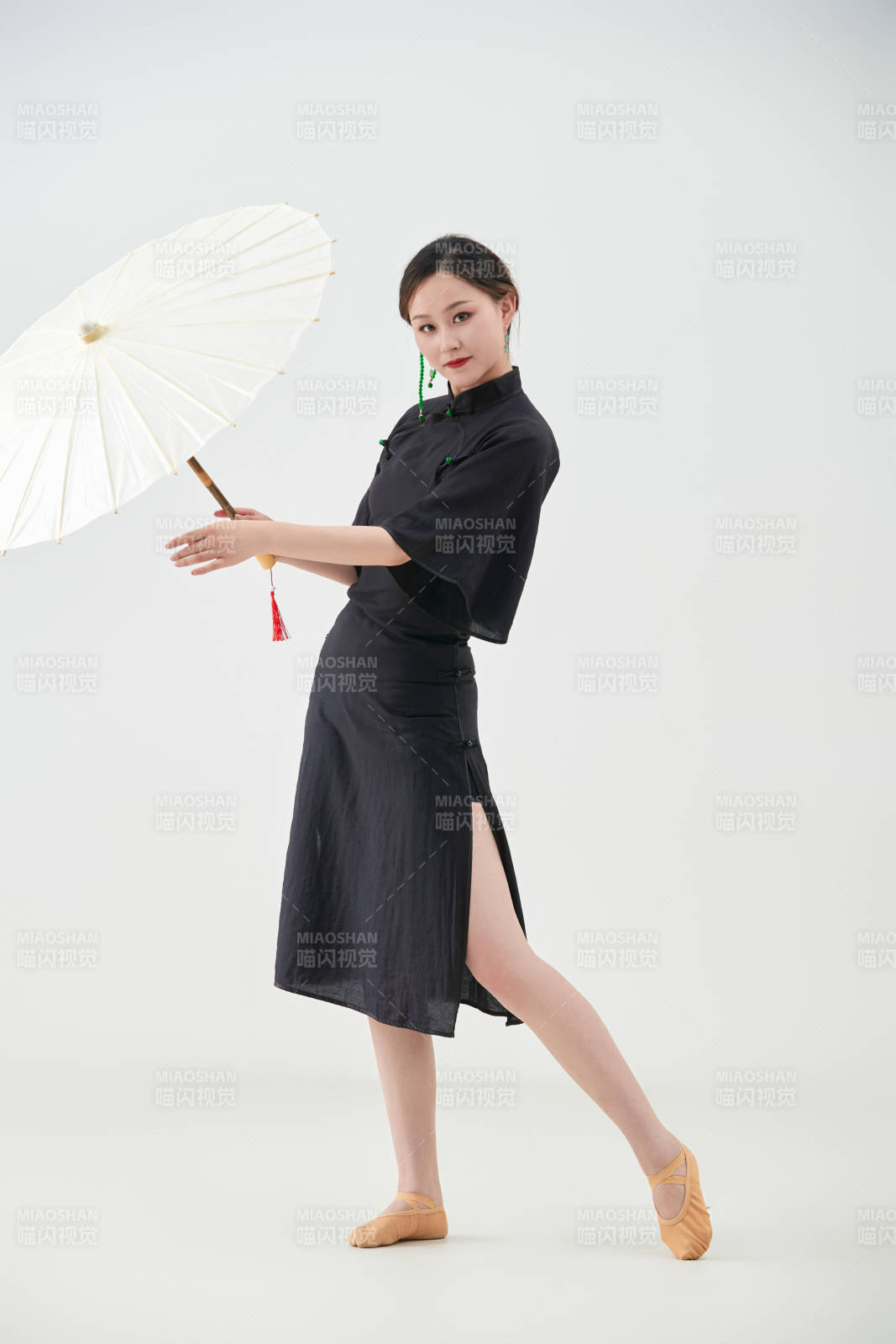 穿中式旗袍手拿油紙傘翩翩舞蹈的亞洲少女舞者