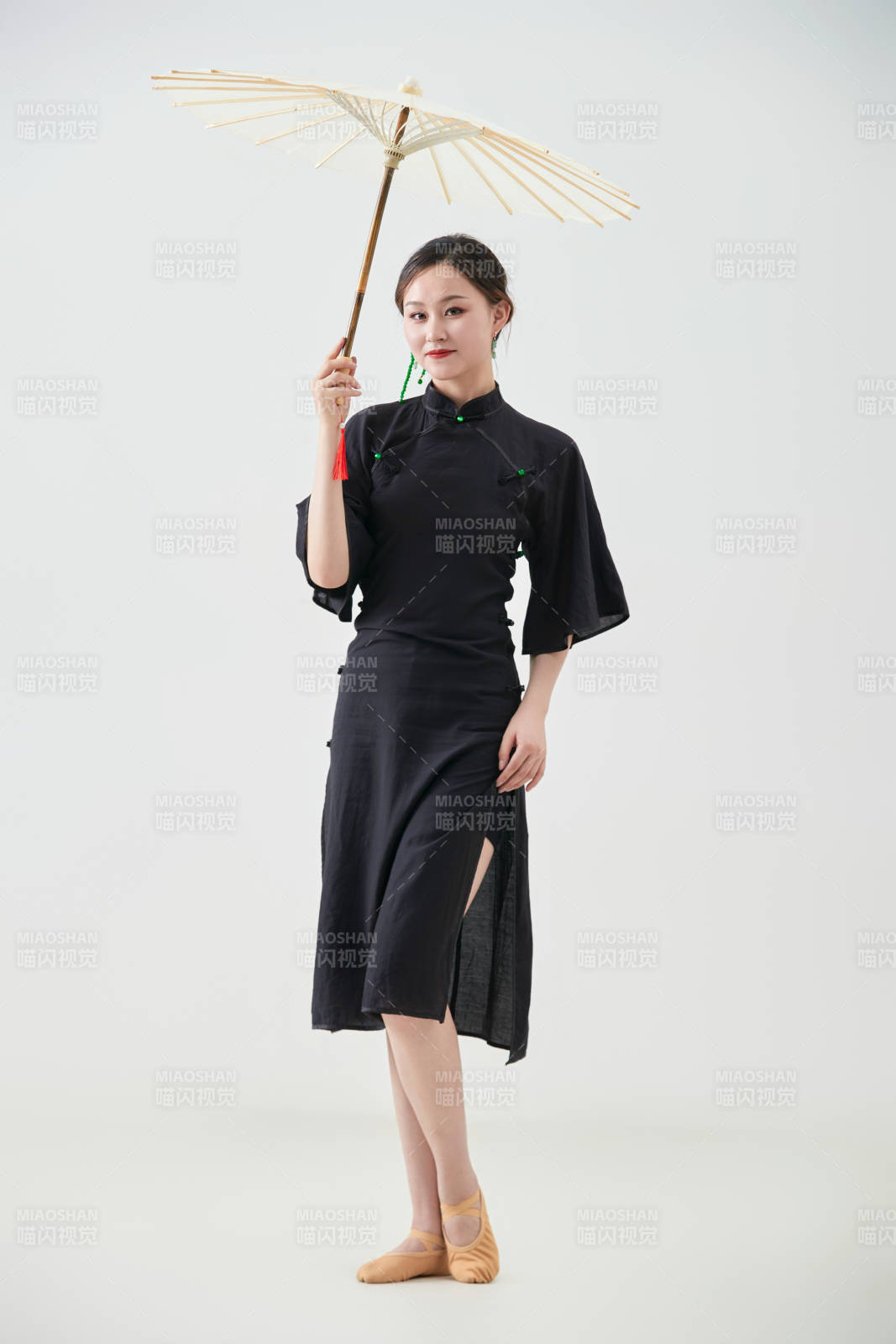 穿中式旗袍手拿油紙傘翩翩舞蹈的亞洲少女舞者