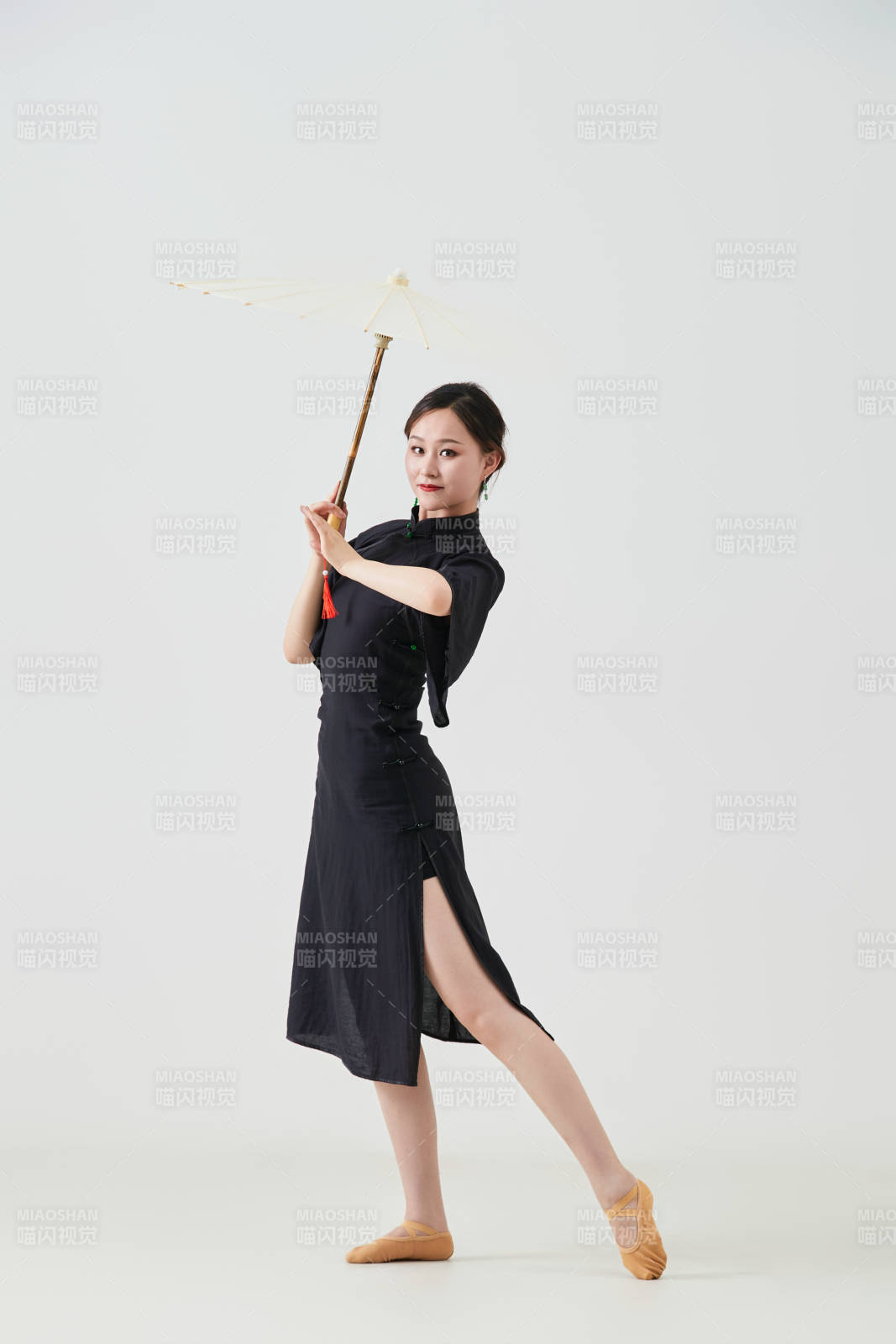 穿中式旗袍手拿油紙傘翩翩舞蹈的亞洲少女舞者
