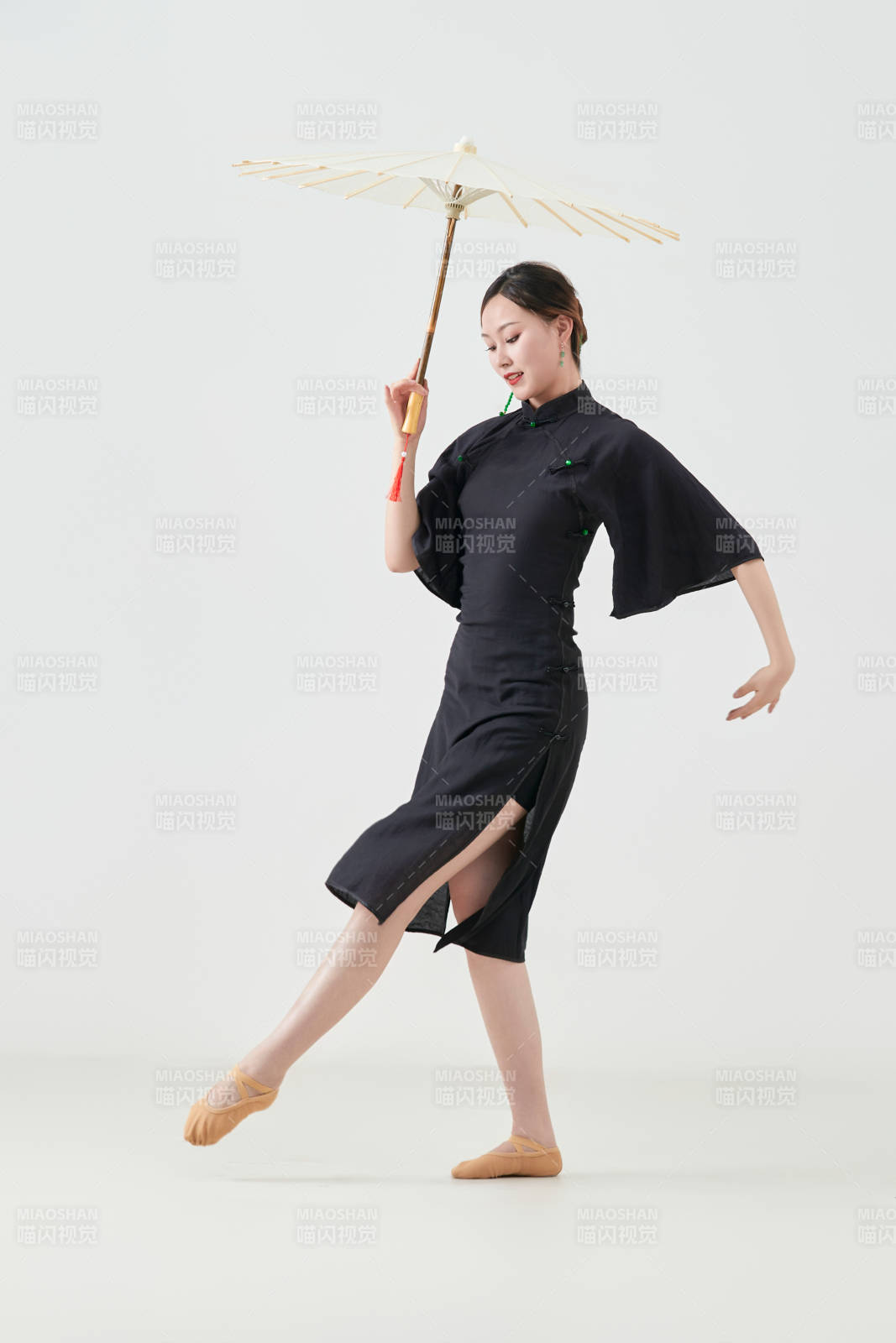 穿中式旗袍手拿油紙傘翩翩舞蹈的亞洲少女舞者