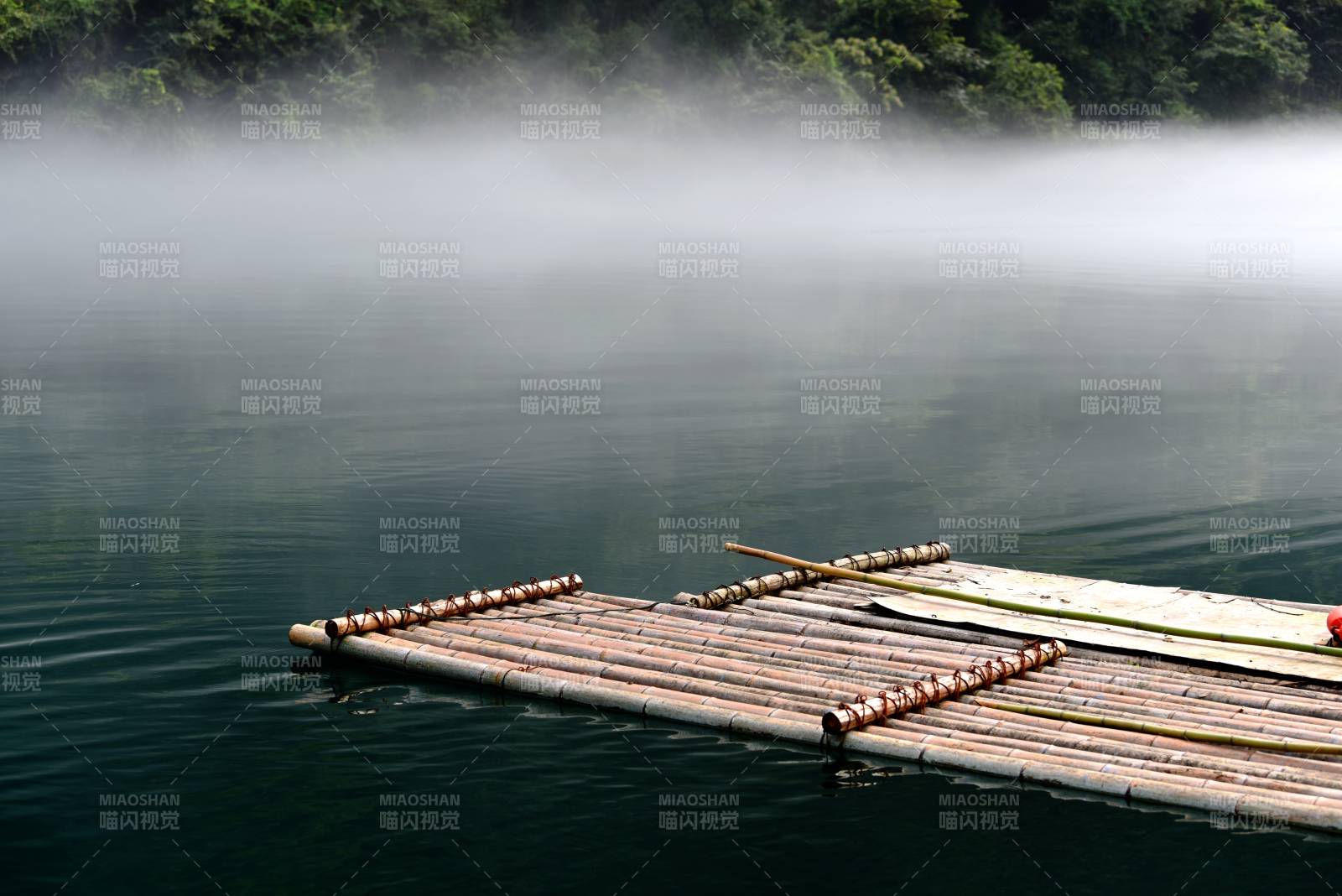 霧中竹筏靜泊湖面