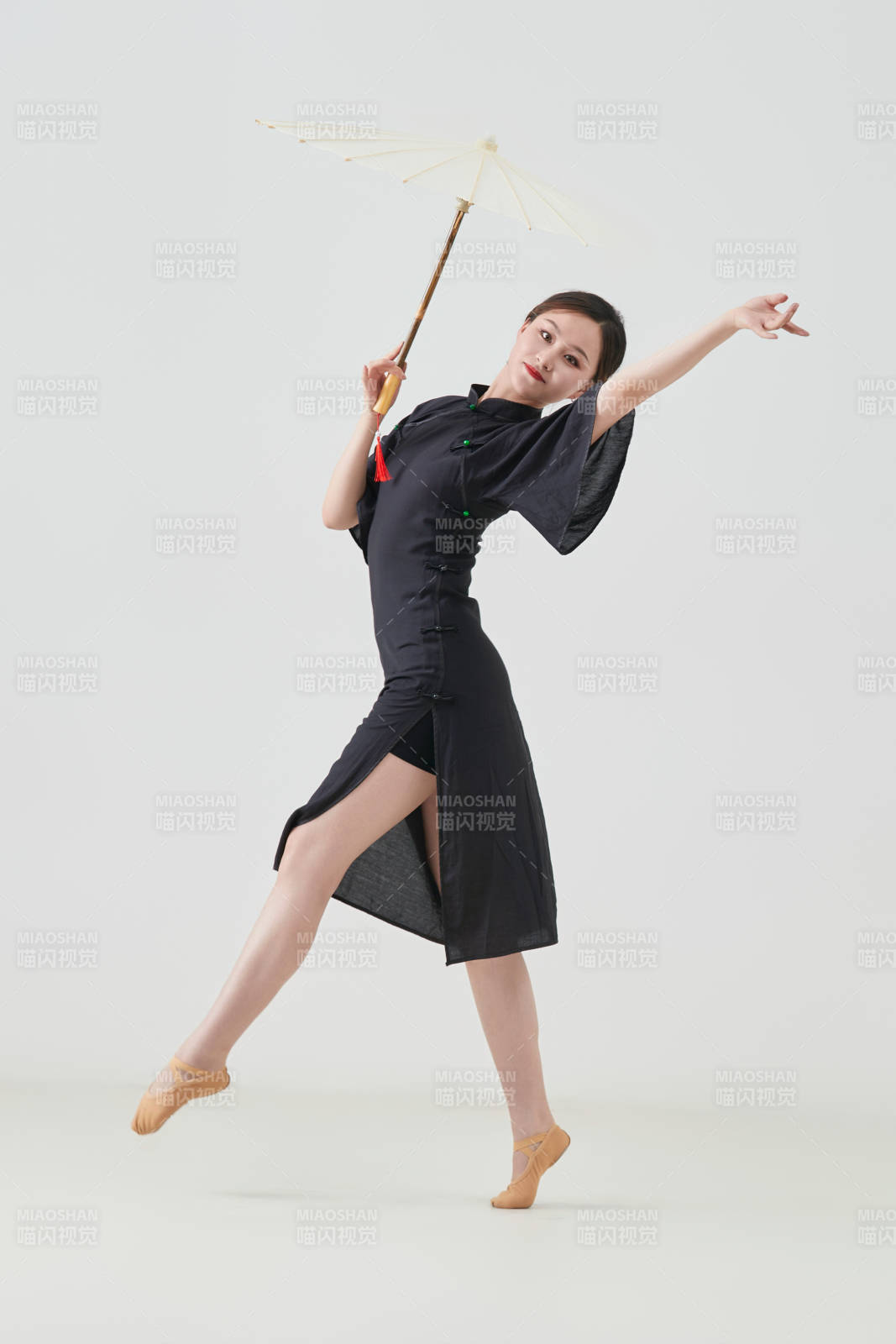 穿中式旗袍手拿油紙傘翩翩舞蹈的亞洲少女舞者